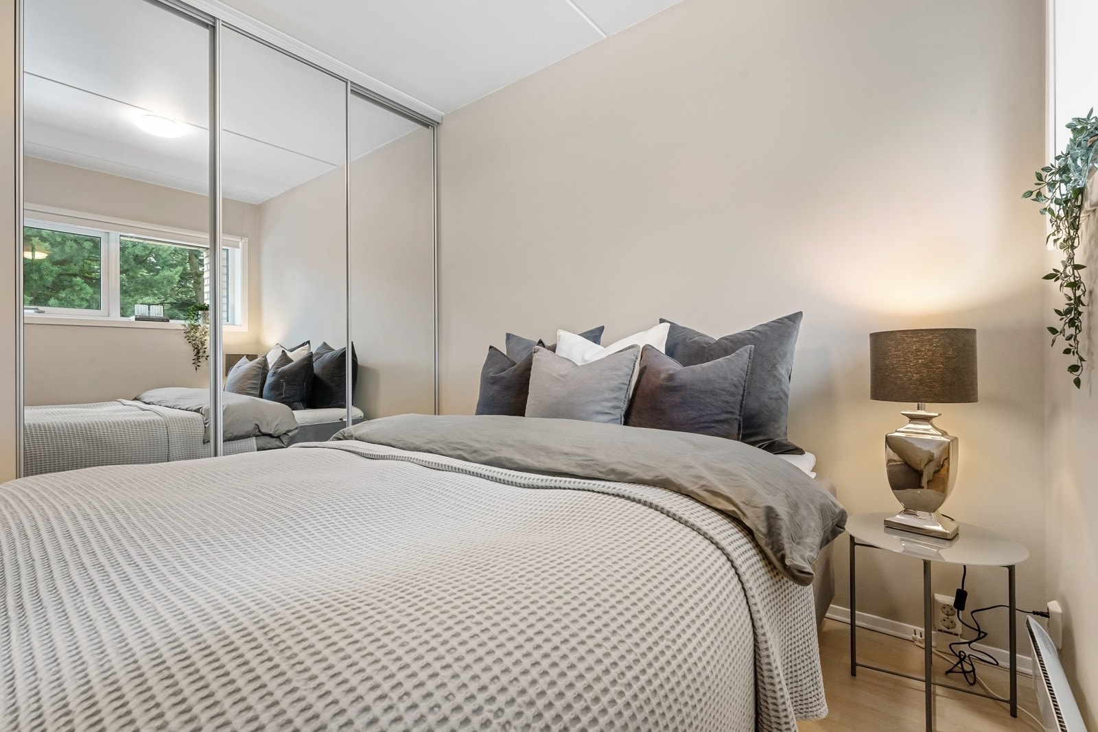 Rommet er av god størrelse og er pent med eikeparkett, dus farge på vegger, to glatte, hvite skyvedører og god plass til dobbeltseng. Langs den ene veggen er det oppført en romslig skyvedørsgarderobe med tre speilfronter. Galleribilde