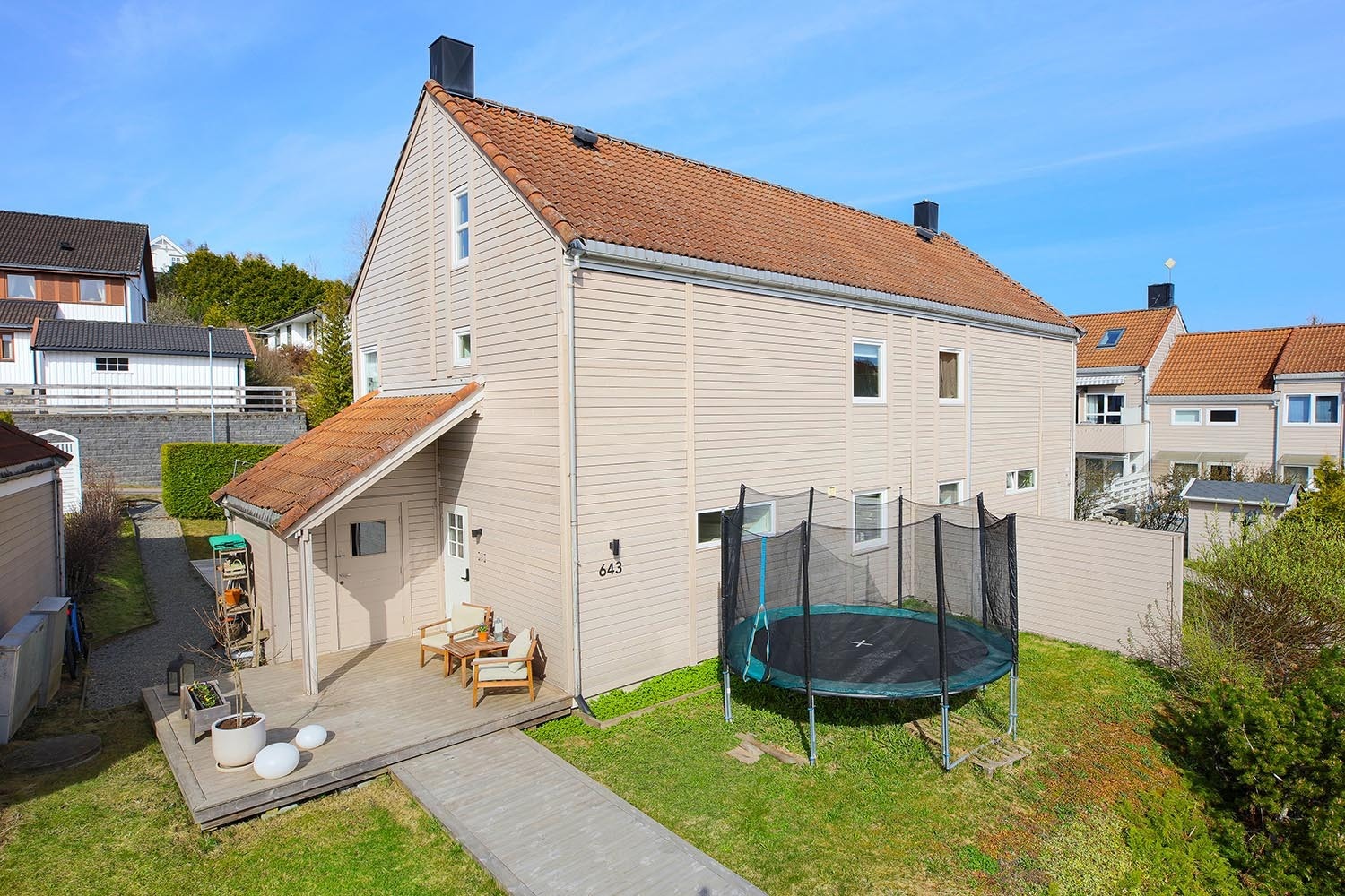 Lett skrånet tomt, pent opparbeidet med plen, prydbusker og trær. Boligen har flere koselige uteplasser, blandt annet ved inngangspartiet og en stor platting på baksiden. Gruset vei mot naboen. Tomten har sol fra morgen til kveld. Galleribilde