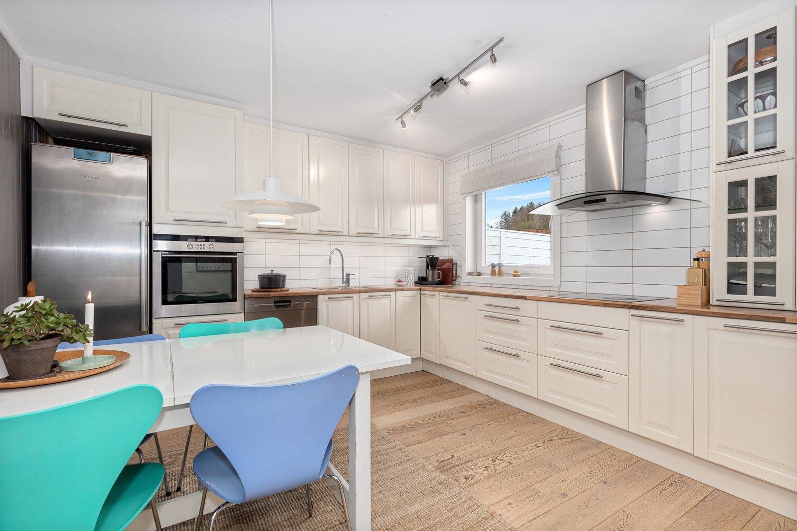 Ikea kjøkkenet tilbyr godt med skap- og benkeplass. Innredningen har profilerte fronter, benkeplate av heltre og fliser på vegg over benk. Galleribilde