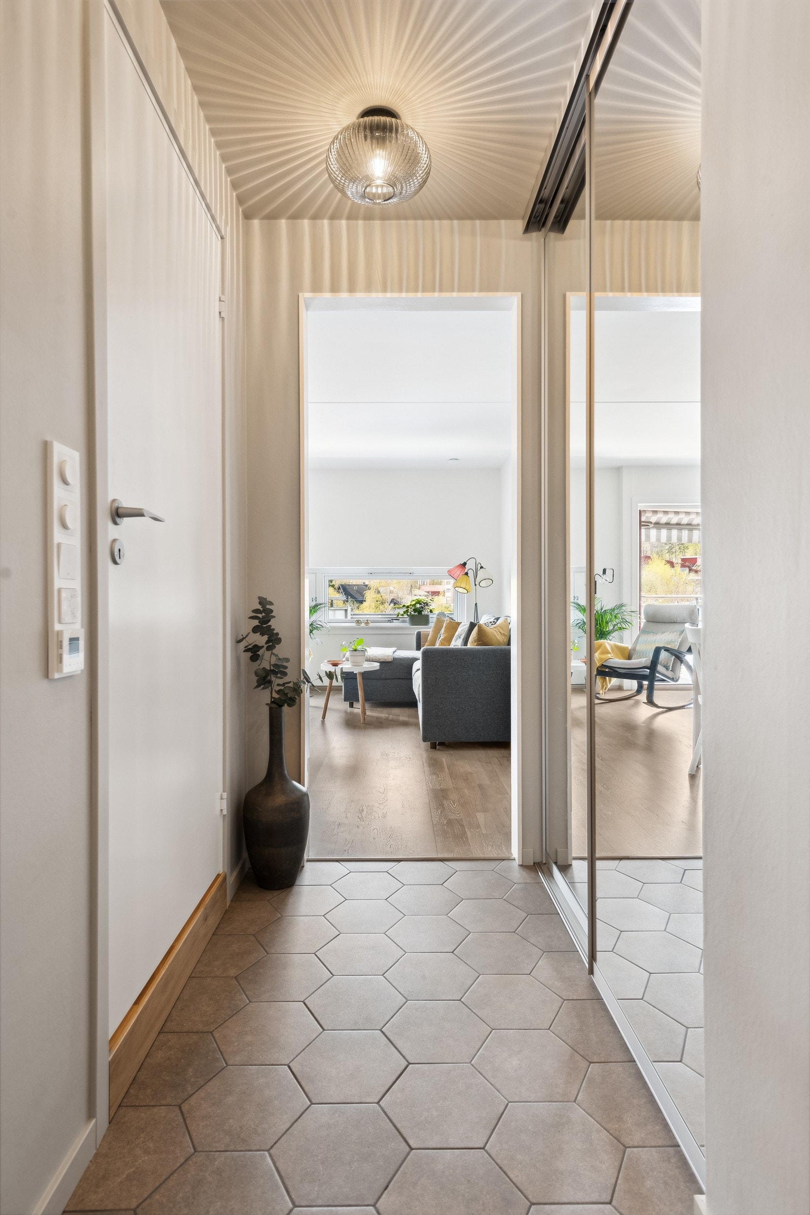 Pen og stilfull entre med fliser på gulv med varmefolie. Ny skyvedørsgarderobe med speilfronter og god oppbevaringsplass. Galleribilde