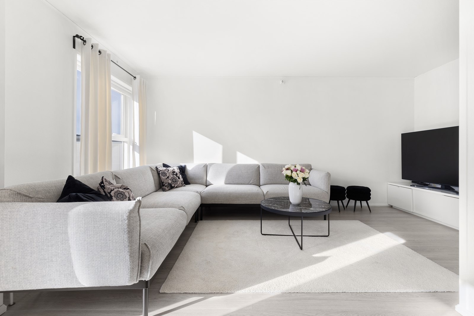 Lys stue med god plass til sofa og tilhørende møblement. Galleribilde