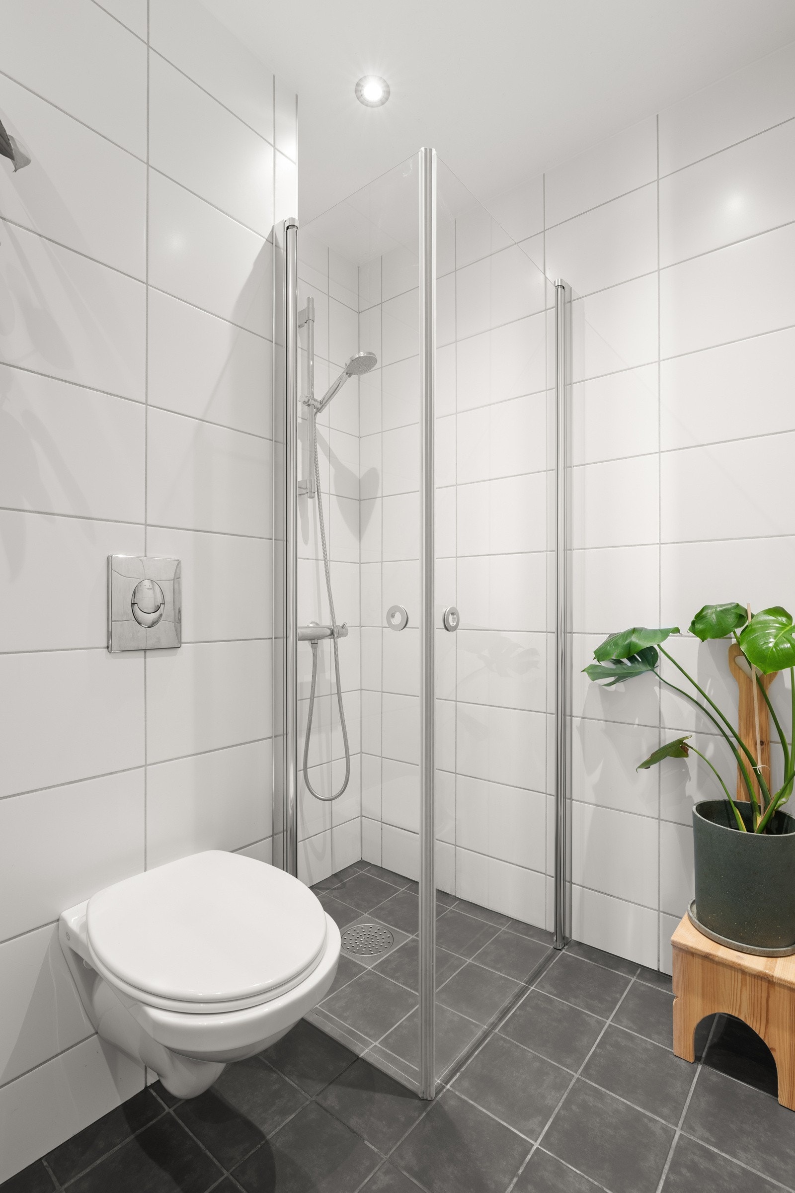 Keramiske fliser på gulv og vegger. Malt gipsplatehimling med innfelte downlights med dimmer. Galleribilde