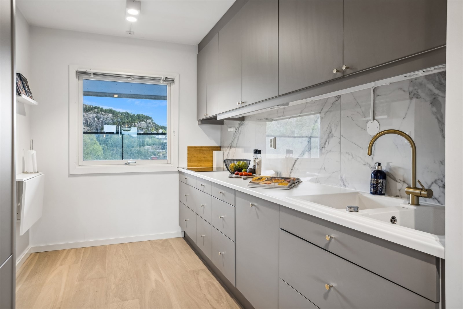 Romslig kjøkken på ca. 9,7 m². Moderne og stilren kjøkkeninnredning med glatte fronter og laminat benkeplate. Galleribilde