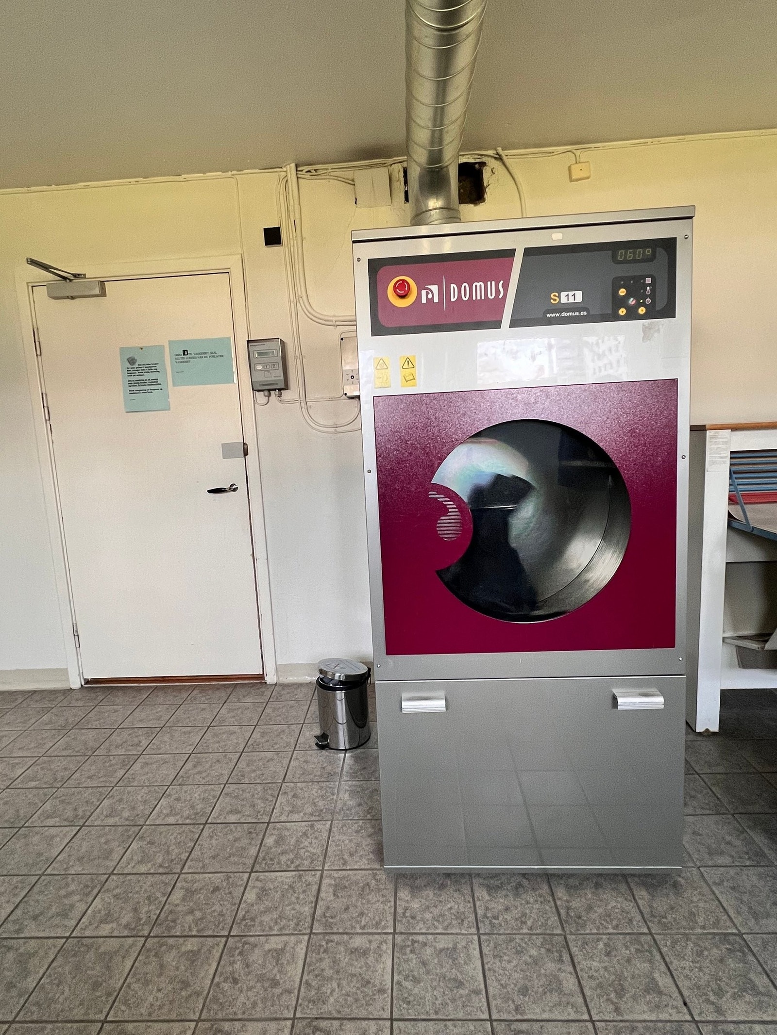 Vaskeri med industri tørketrommel og tøyrulle. Galleribilde