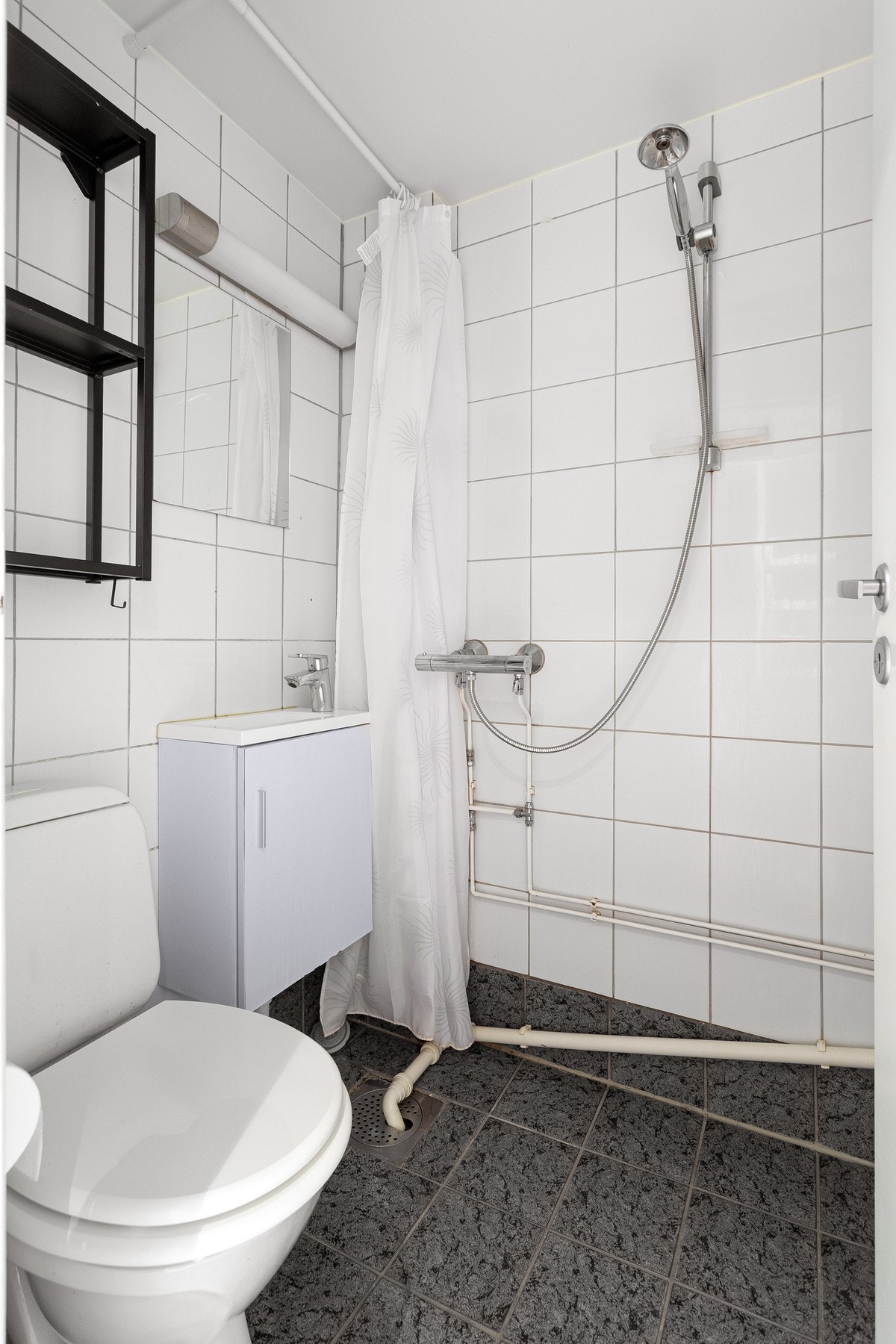 Flislagt bad utstyrt med dusj, toalett og varmekabler i gulv. Galleribilde
