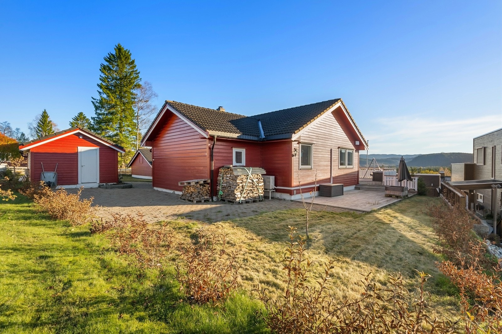 På øverste plan er tomten opparbeidet med steinbelagte områder og gressplen. Galleribilde