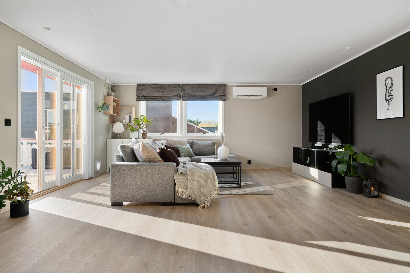 Dagslyset strømmer inn via store stuevinduer i to himmelretninger. Galleribilde