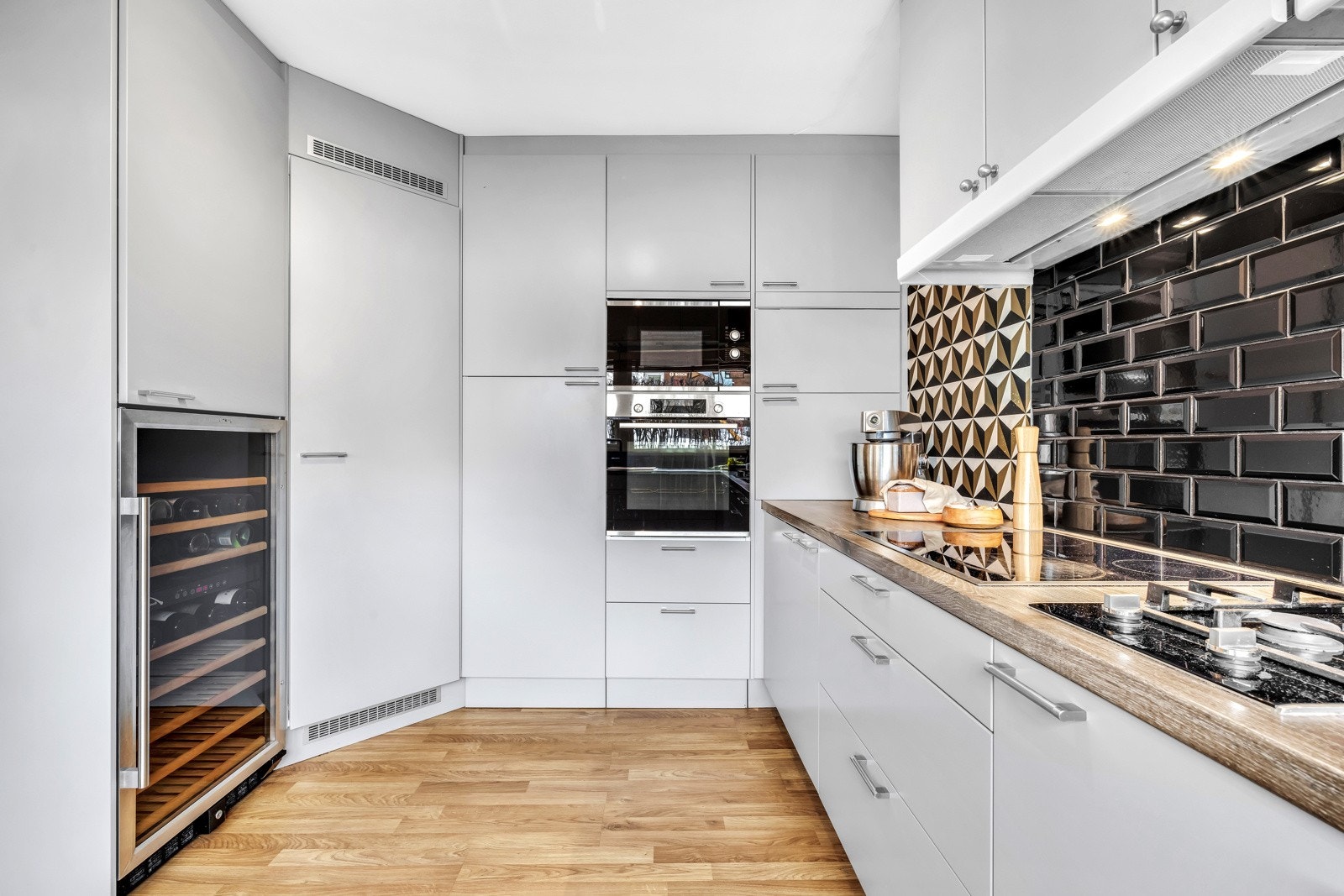 Kjøkkeninnredningen har glatte fronter og en benkeplate av laminat, som kombinerer stil med enkel vedlikehold. Galleribilde