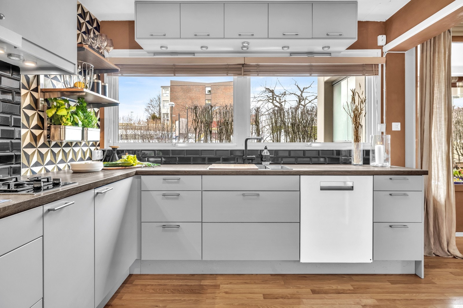 Mellom benkeplaten og overskapene er det en flislagt flate, og benkeskapsbelysning under overskapene gir godt lys på arbeidsområdet. Galleribilde