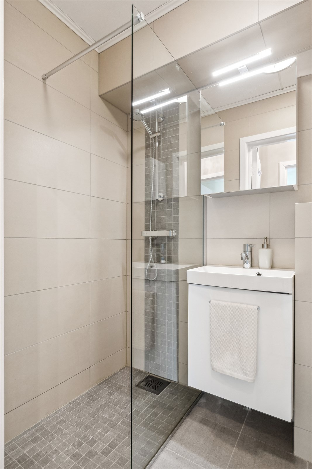 Badet er utstyrt med dusjhjørne, servant og toalett. Galleribilde