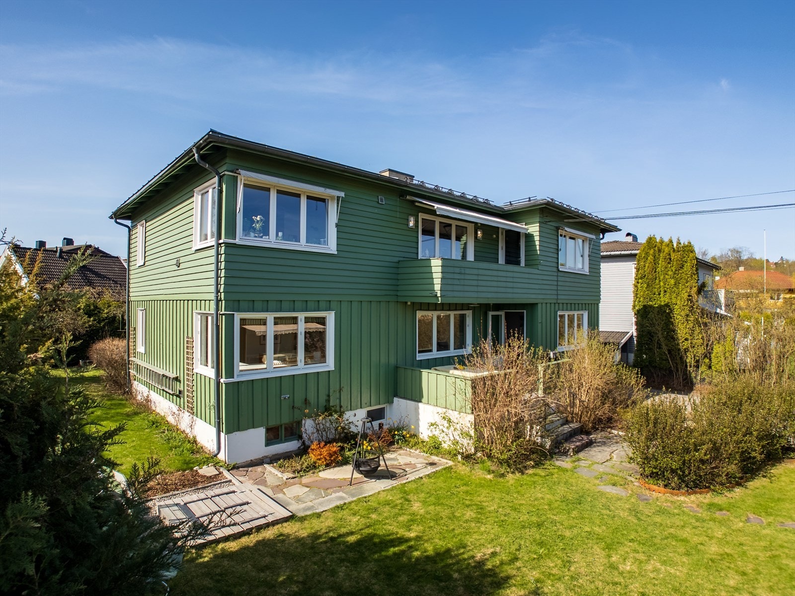 Naturlig tomteskille mellom enhetene. Grensen er på hjørnet av huset ved blomsterbedet. Galleribilde