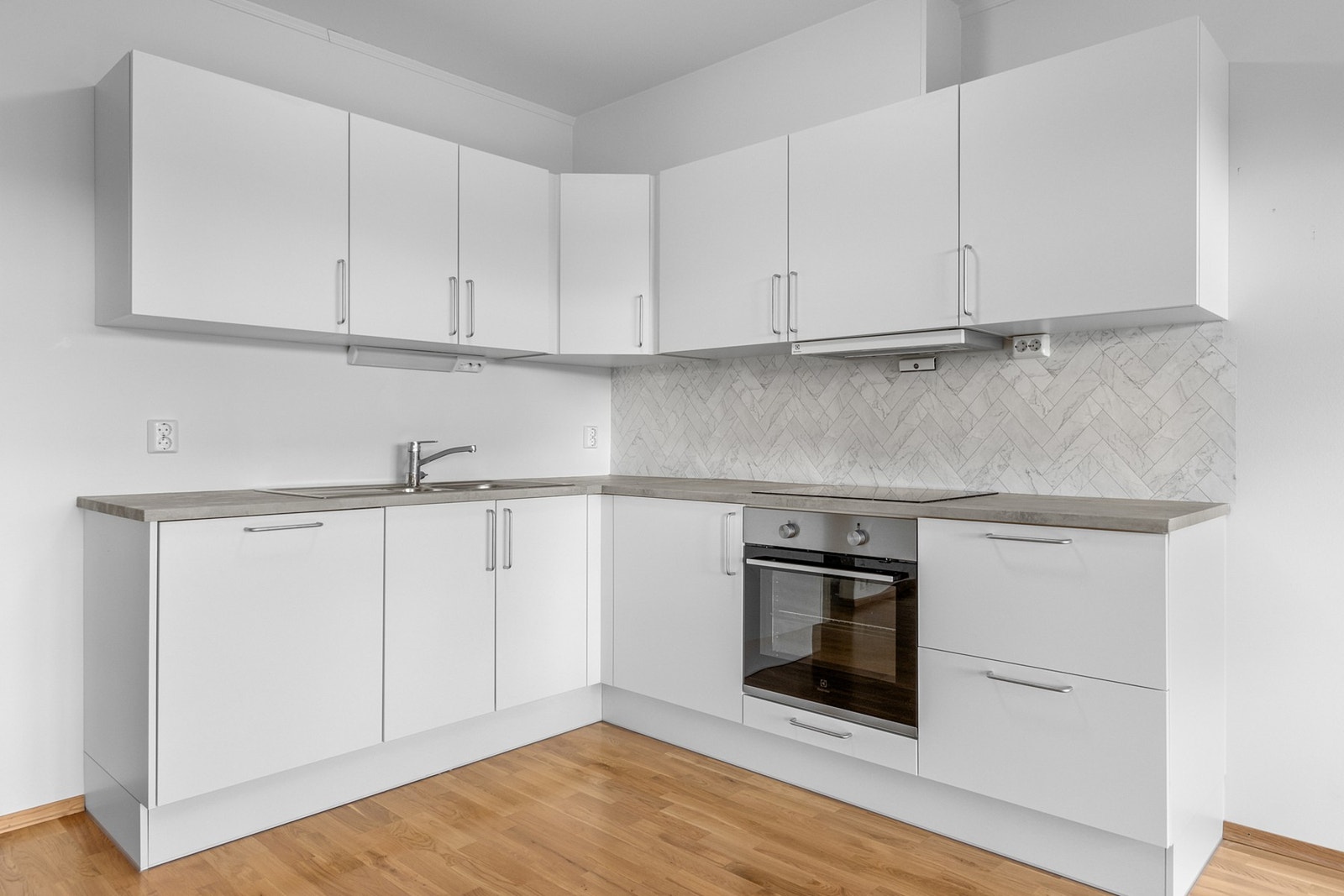 Pent kjøkken med integrert steketopp, komfyr, vaskemaskin og avtrekksvifte. Galleribilde