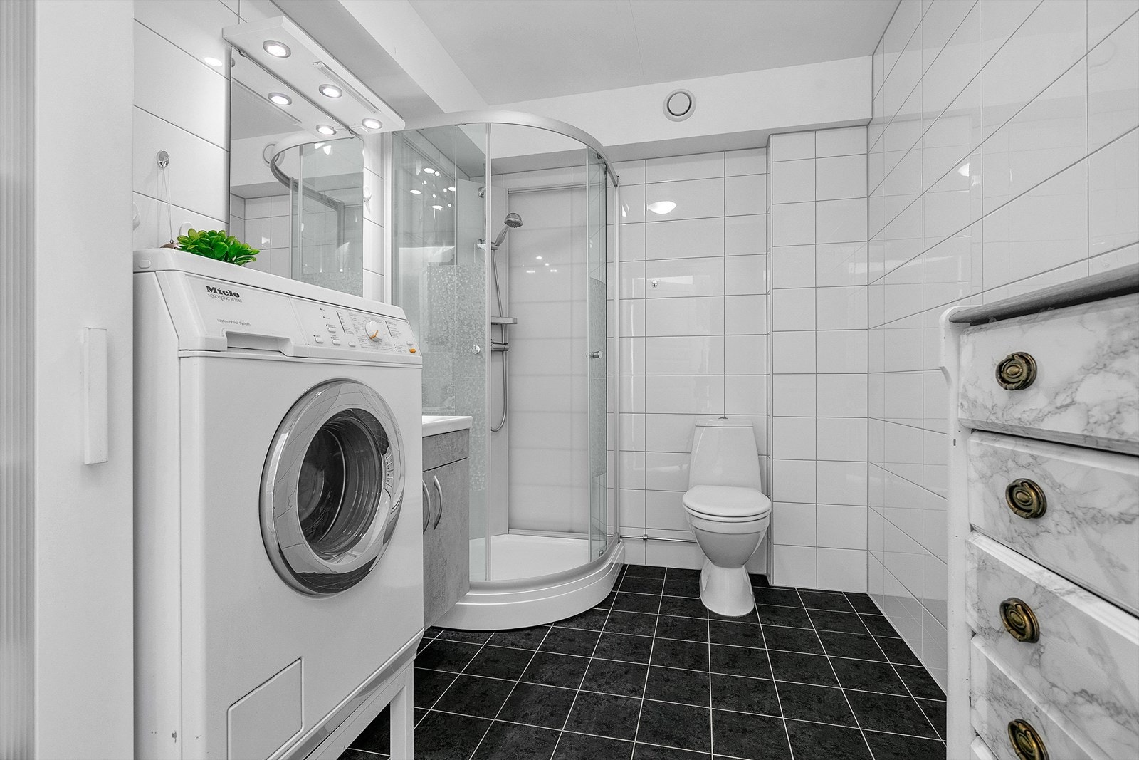 Flislagt bad med god plass for oppbevaringer Galleribilde