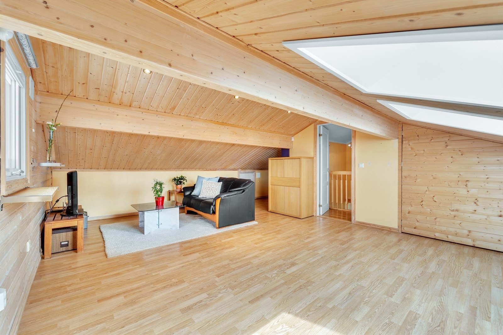 Loftsetasje på øverste plan med plass til stuemøbler og tv. Galleribilde