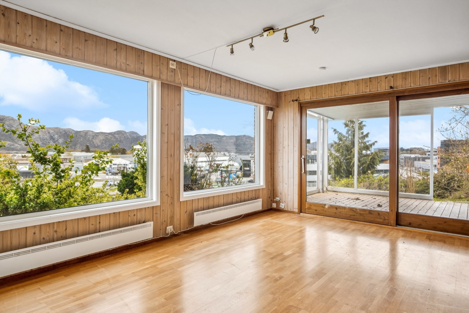 Leilighet - Stuen bærer preg av store vinduer og god plass, utgang til delvis innglasset uteplass Galleribilde