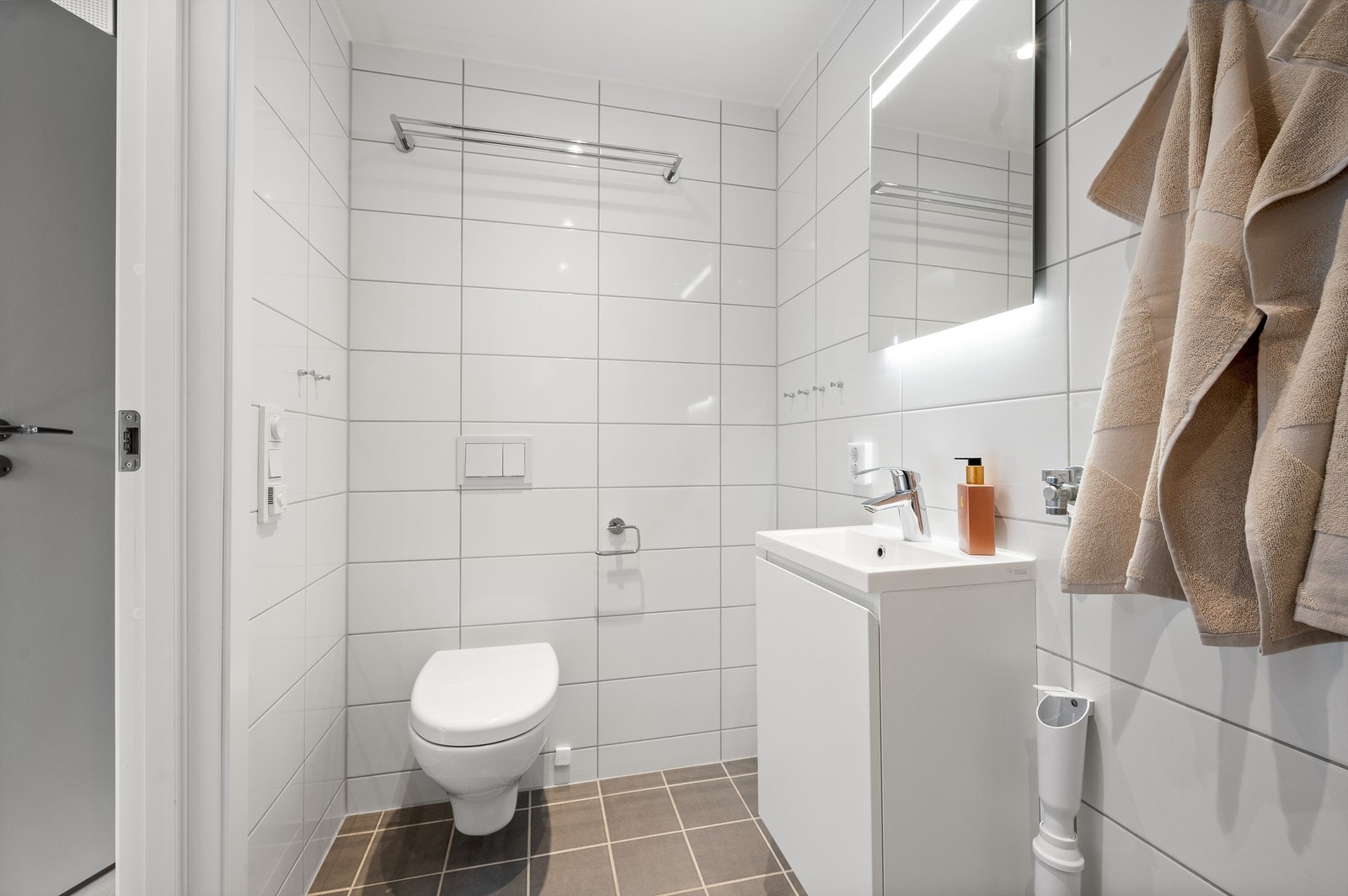 Badet er delikat med flislagte overflater, samt varme i gulvet og downlights i himling. Innredningen består av vegghengt toalett, servant nedfelt i innredning og dusjhjørne med svingbare glassdører. Opplegg for vaskemaskin. Galleribilde