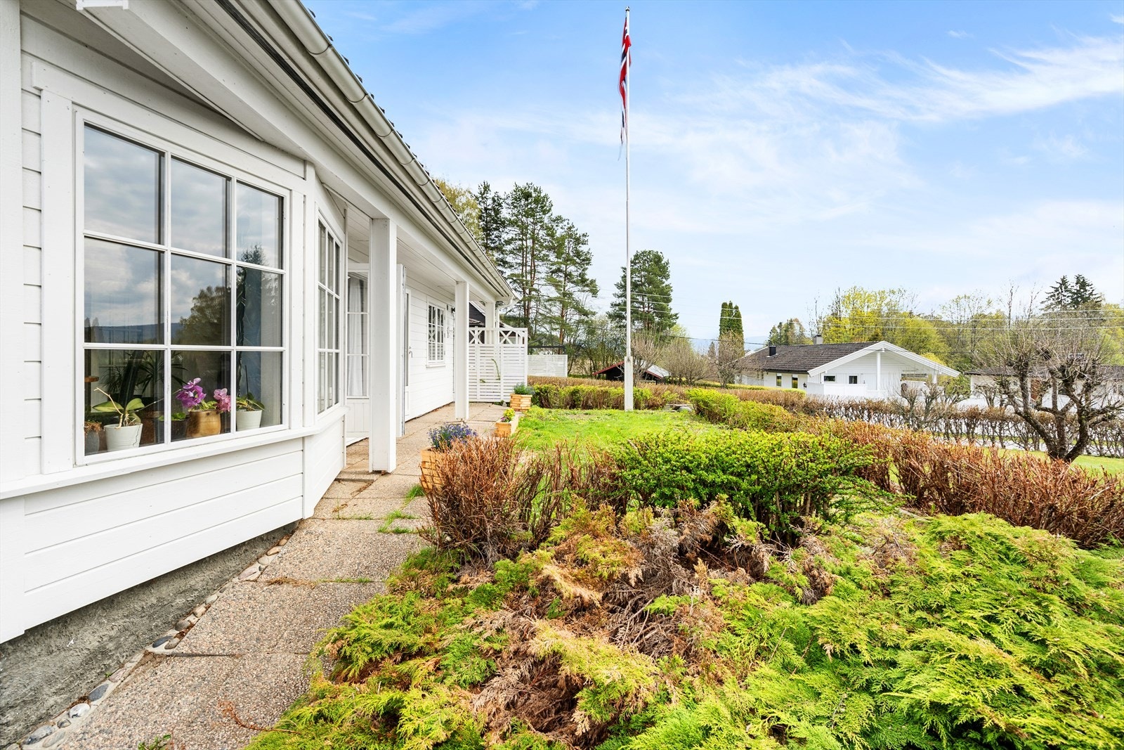 Uteområdene er pent opparbeidet med diverse beplantninger, bed avgrenset med kantsteiner og gress-arealer. Galleribilde