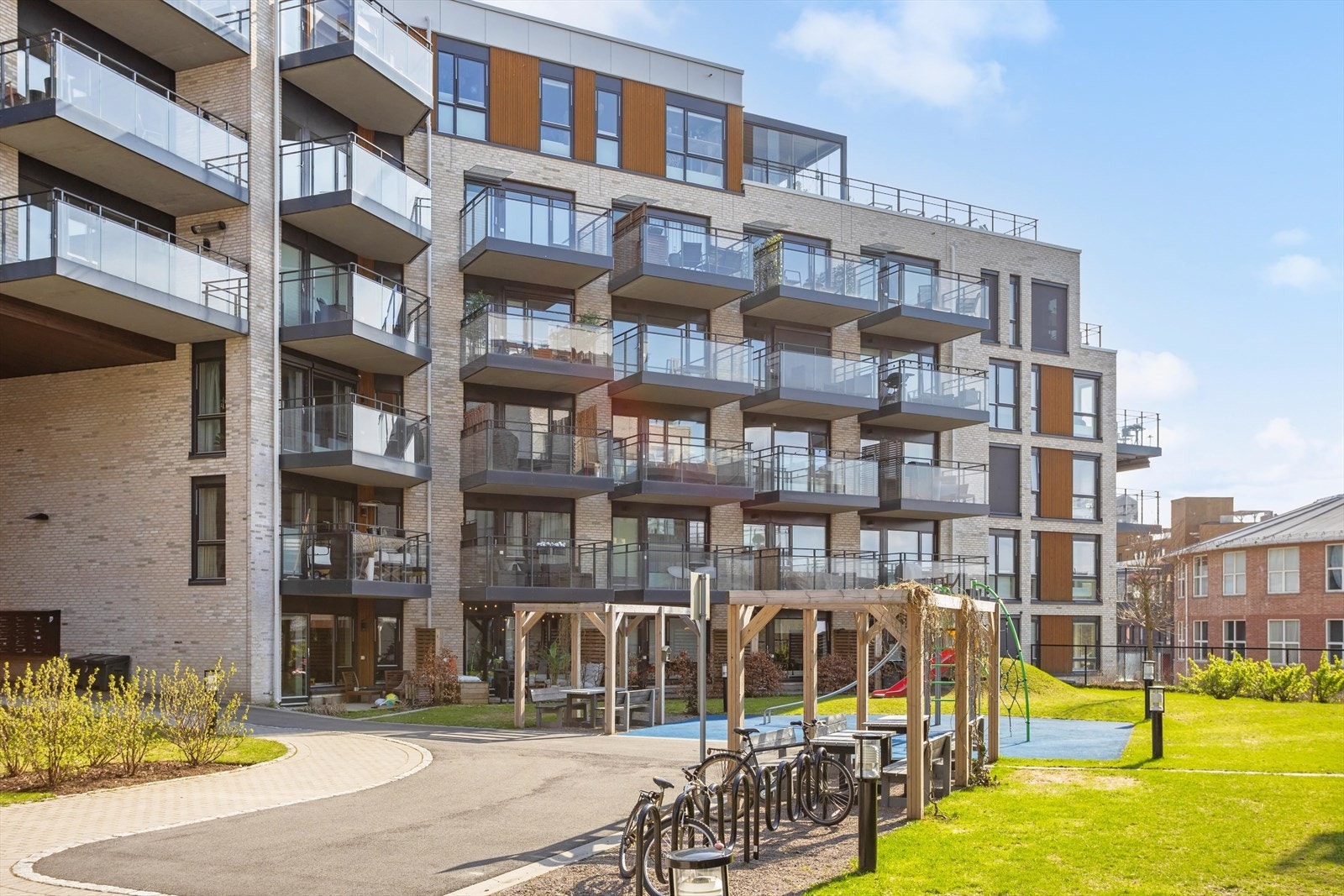 Koselig og solrik bakgård med opparbeidet grøntområde, sitteplasser og sykkelparkering Galleribilde