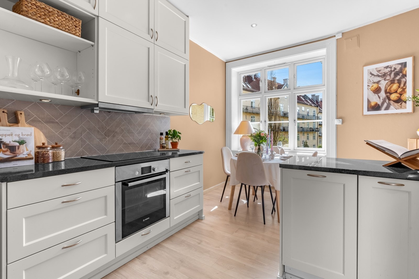 Stilrent kjøkken fra 2015 (iht. forrige salgsoppgave) med hvite profilerte fronter, kitchenboards på vegg over benk og benkeplate i granitt. Galleribilde