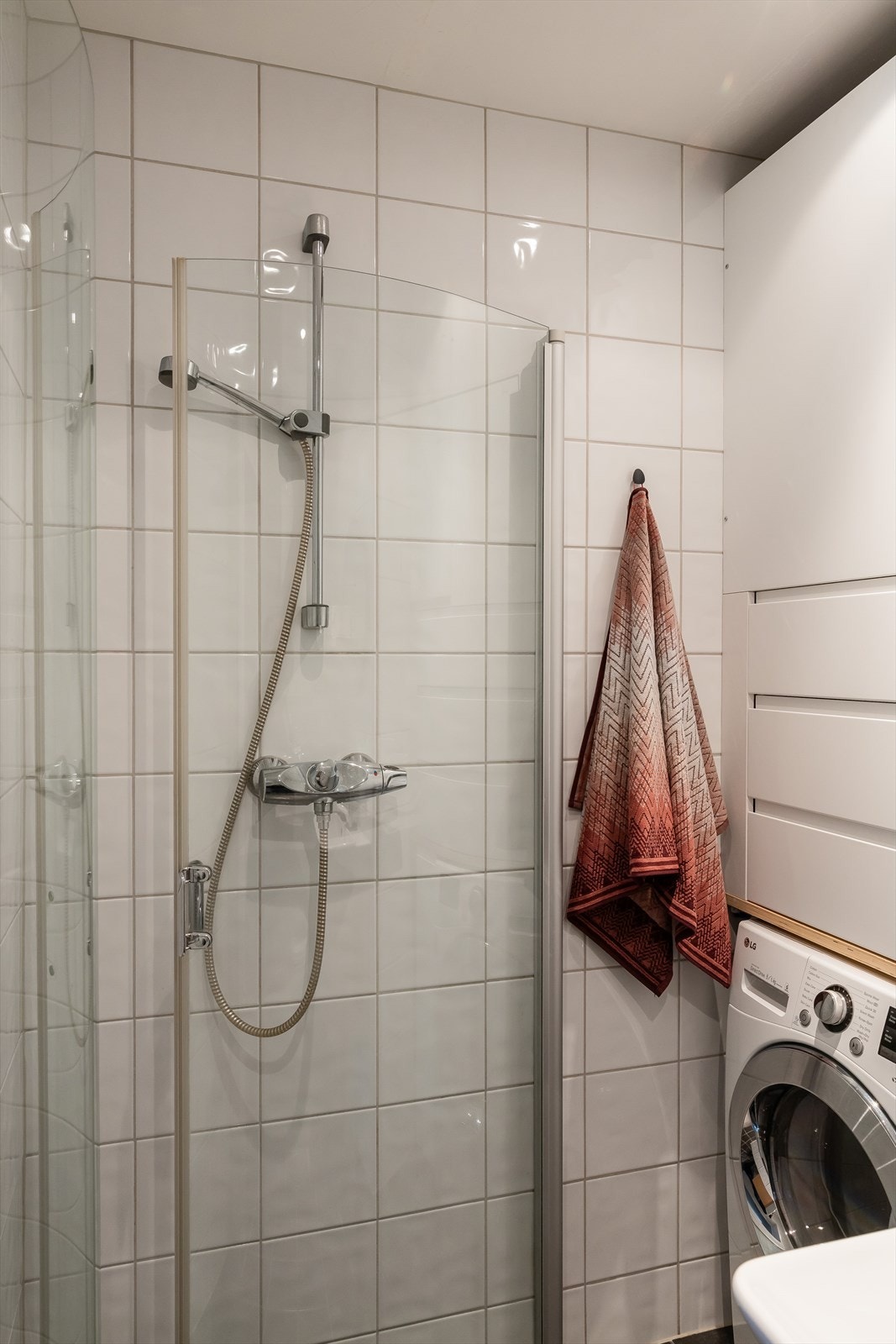 Badet er utstyrt med en servant med underskap, speil, stikk, toalett og dusjsone med innfellbare glassdører. Det er opplegg for vaskemaskin. Galleribilde