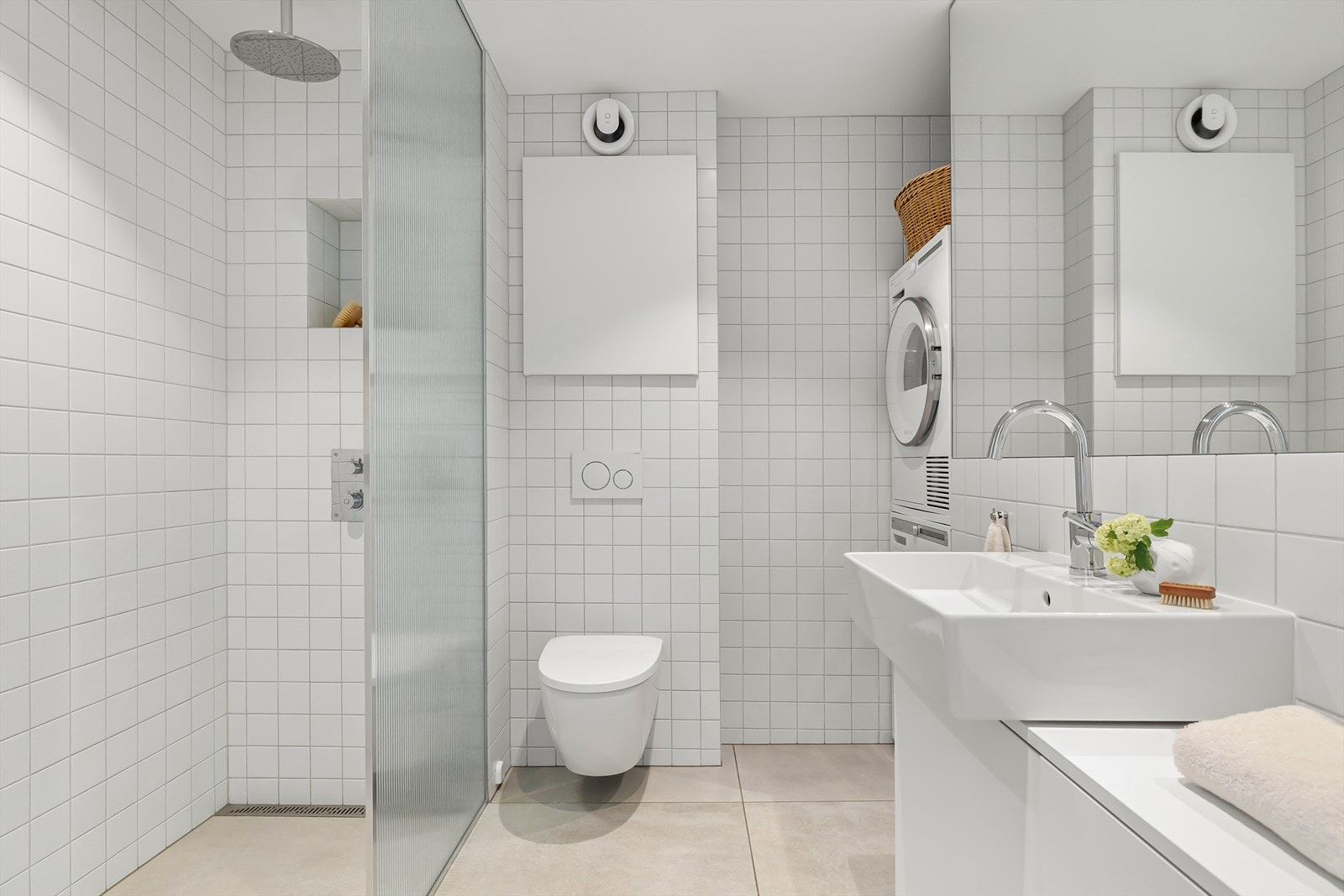 Leilighetens bad er romslig og lekkert helfliset i lyse og delikate farger. Galleribilde