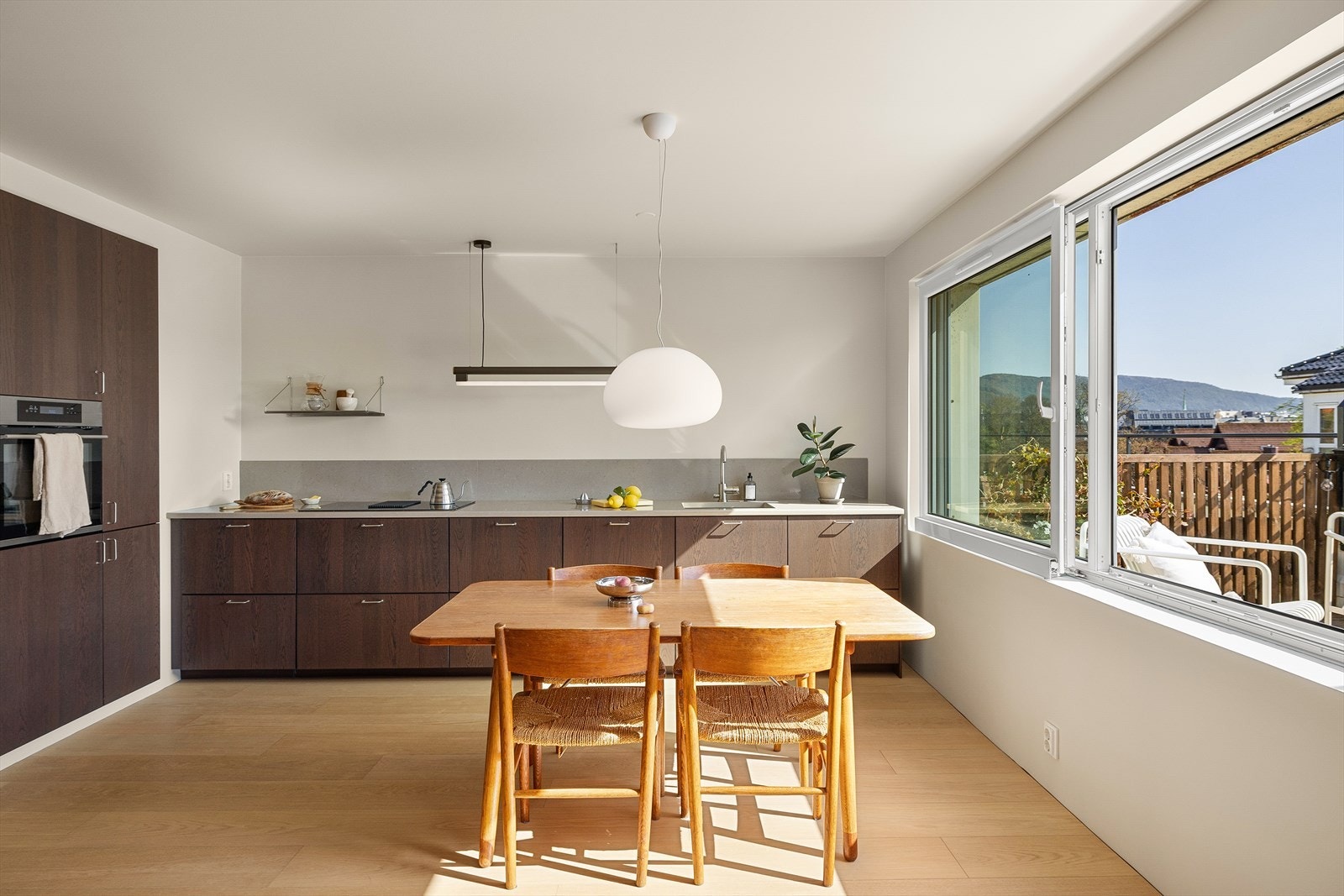 Lekker og moderne kjøkkeninnredning fra 2021 utført med fronter i eikefinér og benkeplate i kompositt med nedfelt vask. Galleribilde