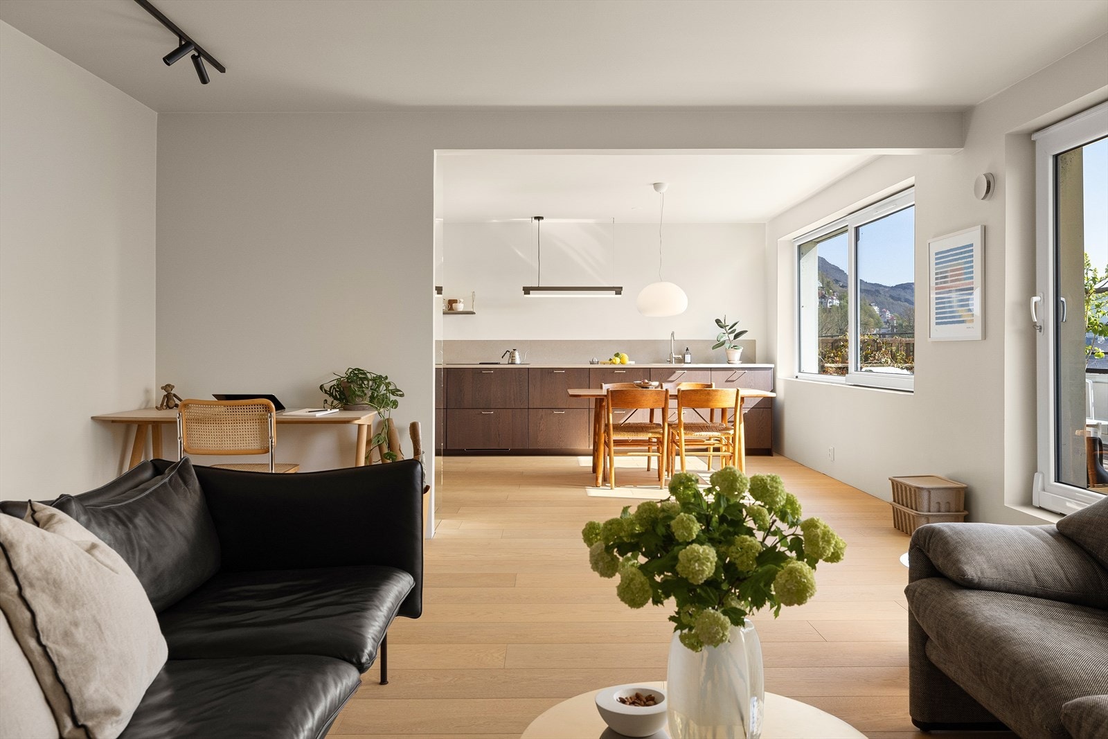 Åpen kjøkkenløsning i stue. Rommet fremstår som et hyggelig og sosialt samlingspunkt med store vindusflater og flott utsikt. Galleribilde