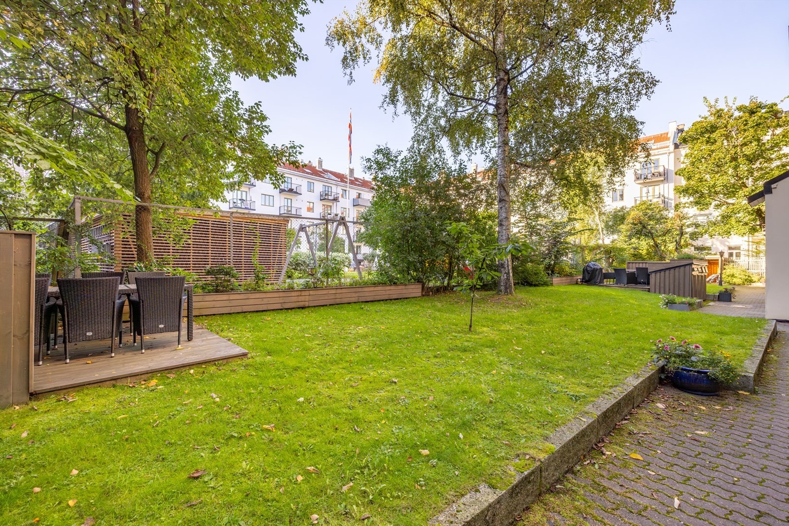 Hyggelig, låst bakgård med sittegrupper, beplantning og sykkelstativer. Galleribilde