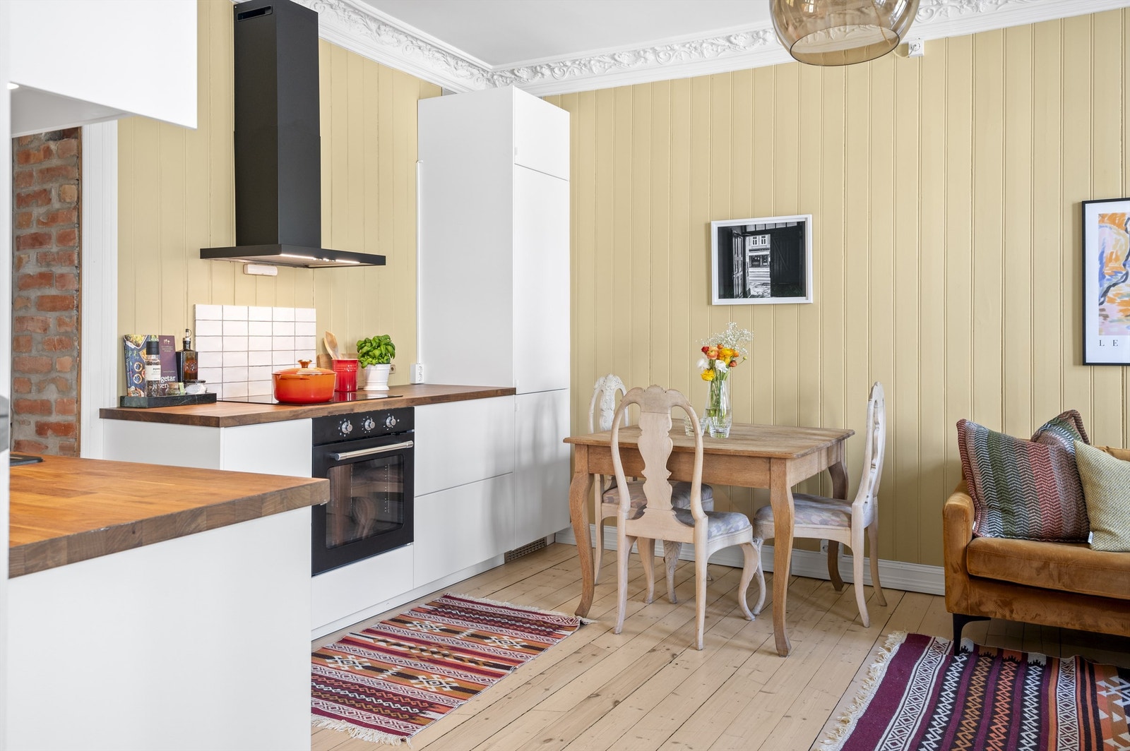 Innredningen er hvit med slette fronter og benkeplater i en kombinasjon av massivt tre og finer, med nedfelt oppvaskkum. Galleribilde