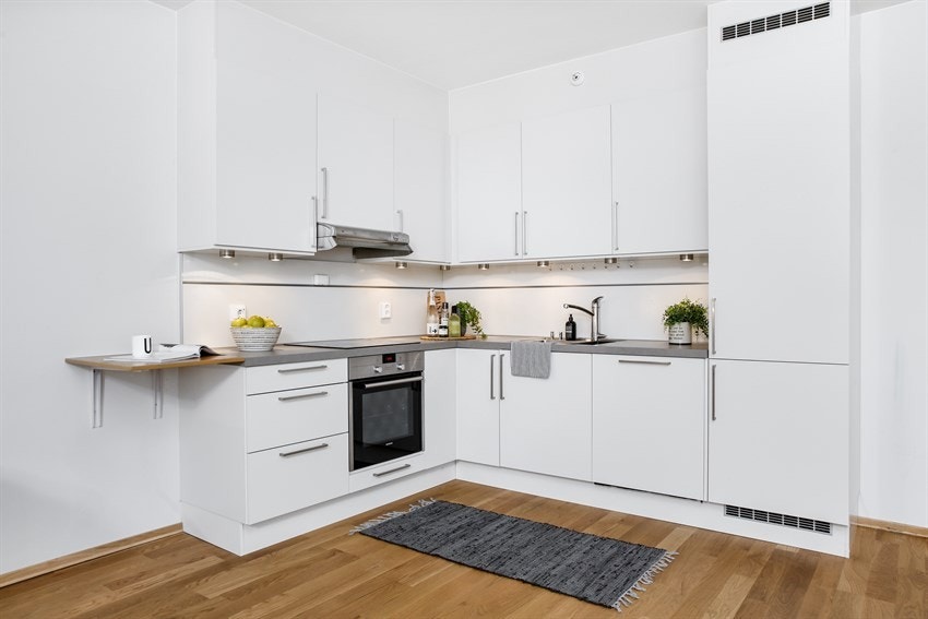 Lyst kjøkken med integrerte hvitevarer Galleribilde