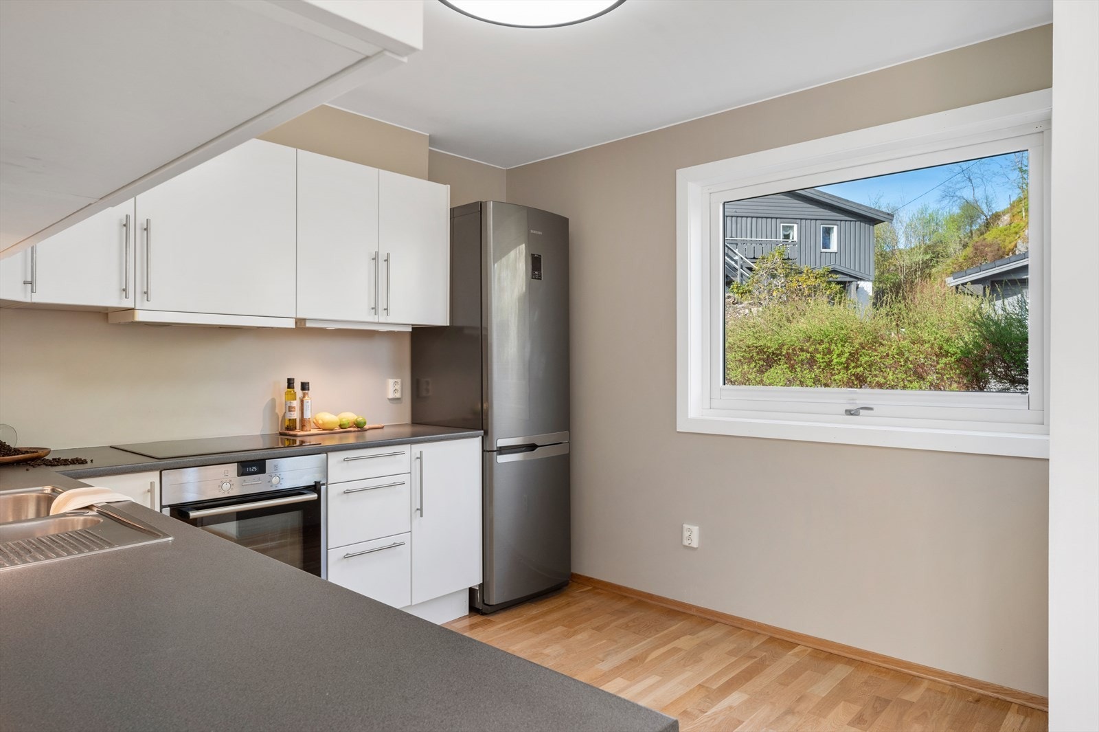 - Klassisk, tidløs kjøkkeninnredning med slette fronter og benkeplate i laminat - Galleribilde