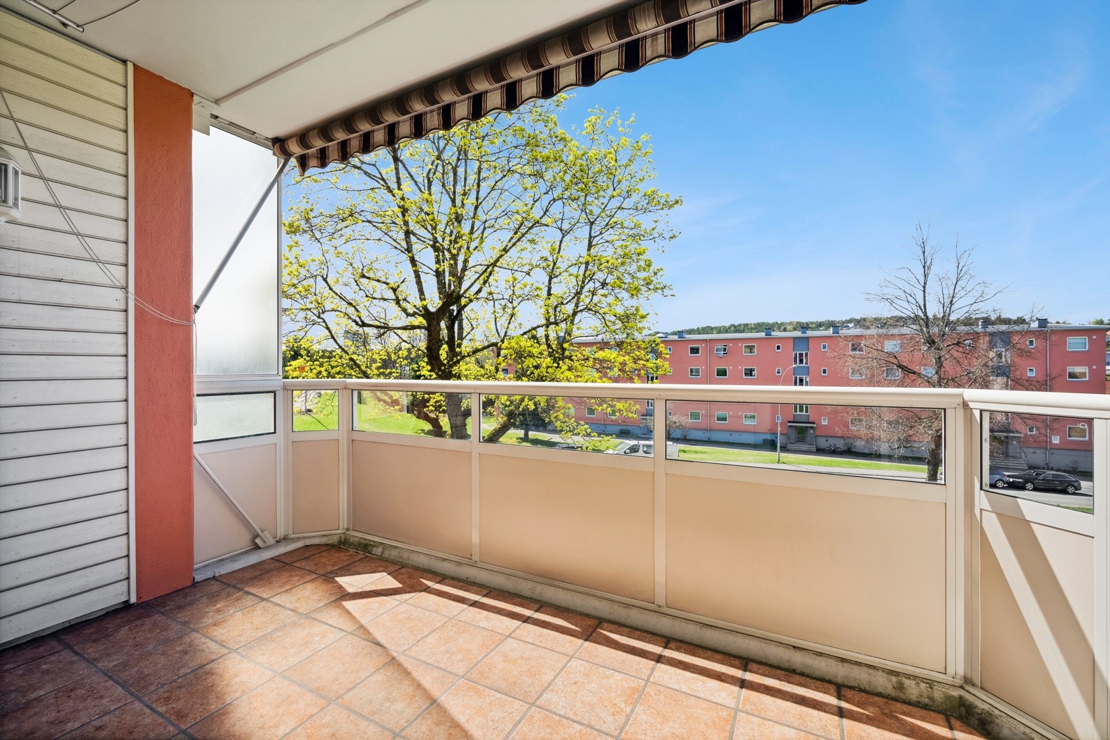 Sydvestvendt balkong på 7m² med fliser på gulv, belysning, strømuttak og markise. Galleribilde