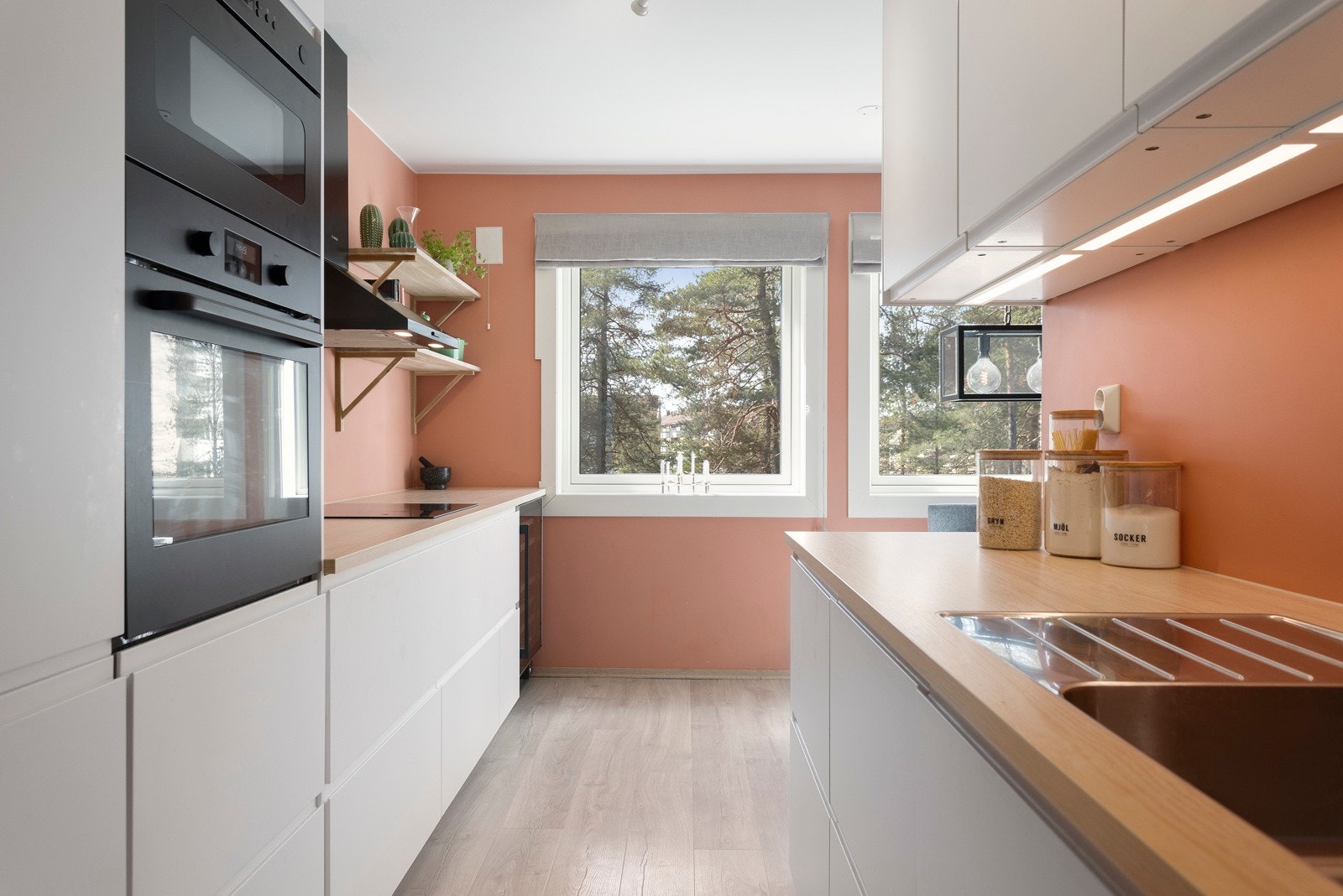 IKEA kjøkkeninnredning fra 2021 med hvite glatte fronter, integrerte håndtak/grep og laminerte benkeplater i imitert tre Galleribilde