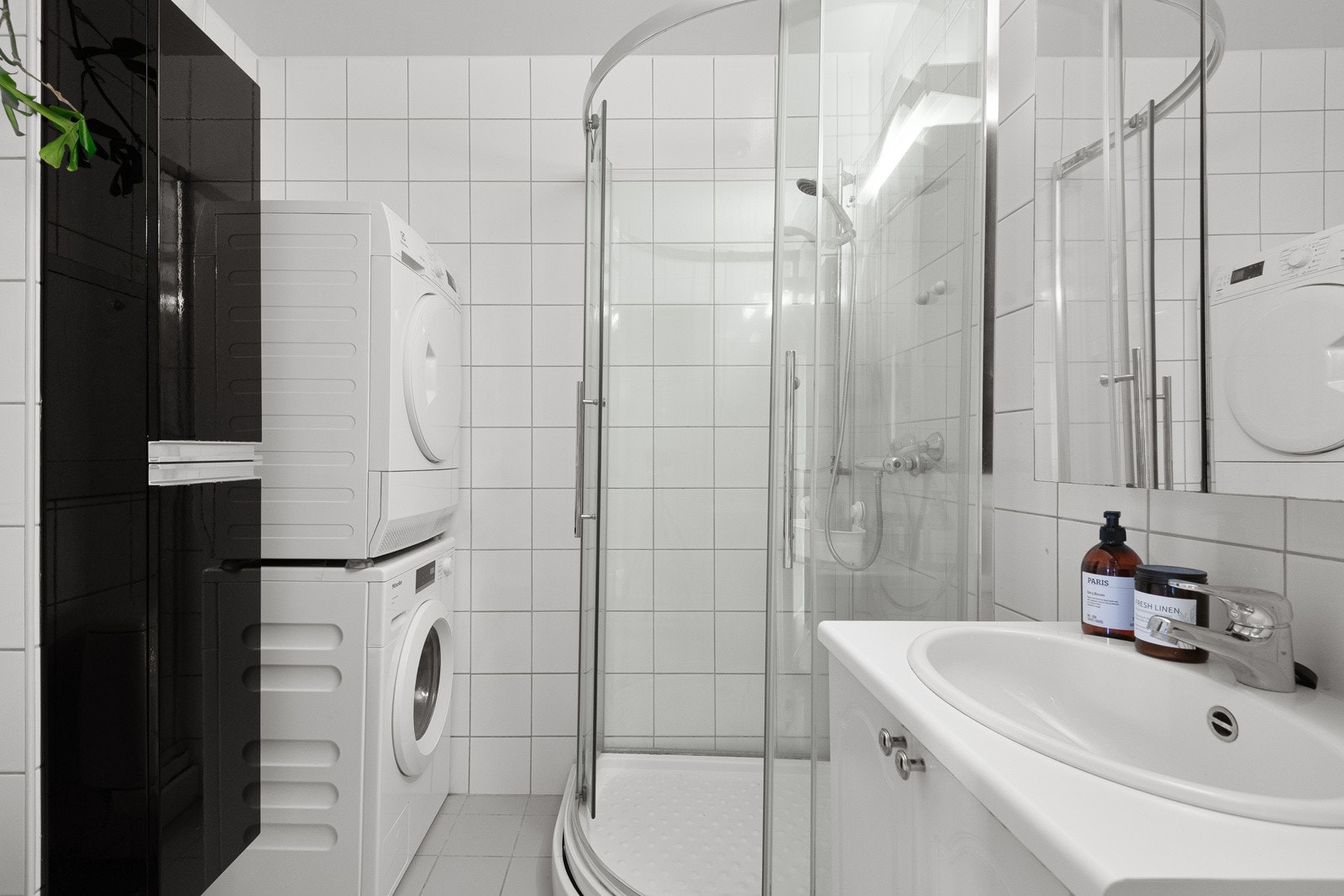 Badet har tidløst flisvalg og innredning. Både vaskemaskin og tørketrommel medfølger salget. Galleribilde