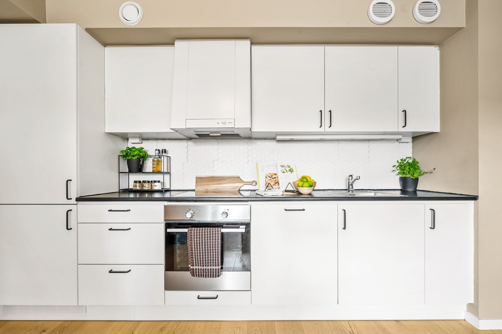 Åpen og sosial kjøkkenløsning. Kjøkkeninnredning fra 2020 med hvite slette fronter og benkeplater av laminat. Galleribilde