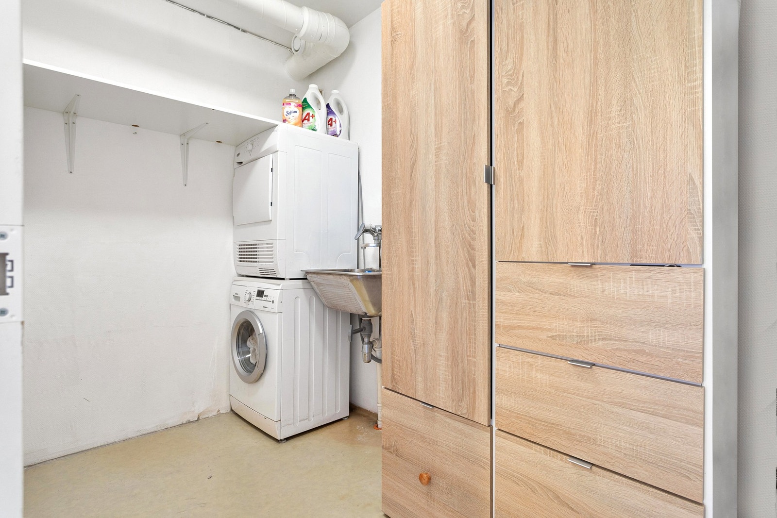 Romslig vaskerom utstyrt med opplegg for vaskemaskin, utslagsvask og mekanisk avtrekk. Galleribilde