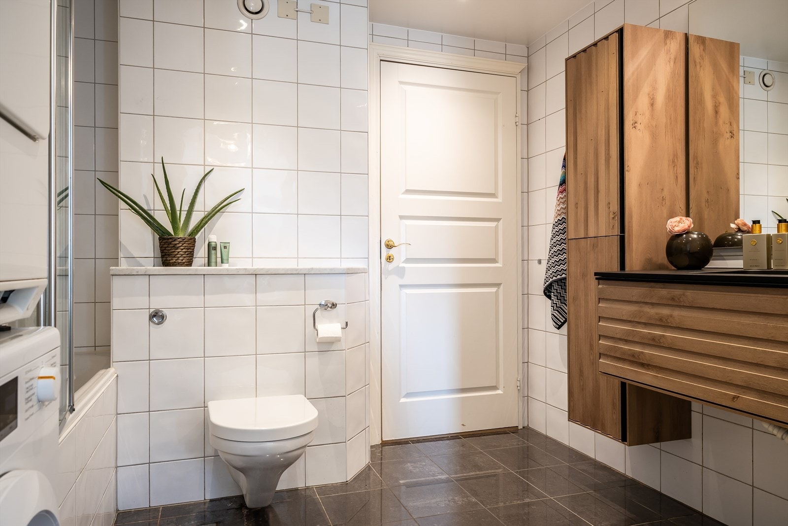 Pent, flislagt bad med dobbelservant, badekar, vaskenisje og varmekabler i gulv Galleribilde