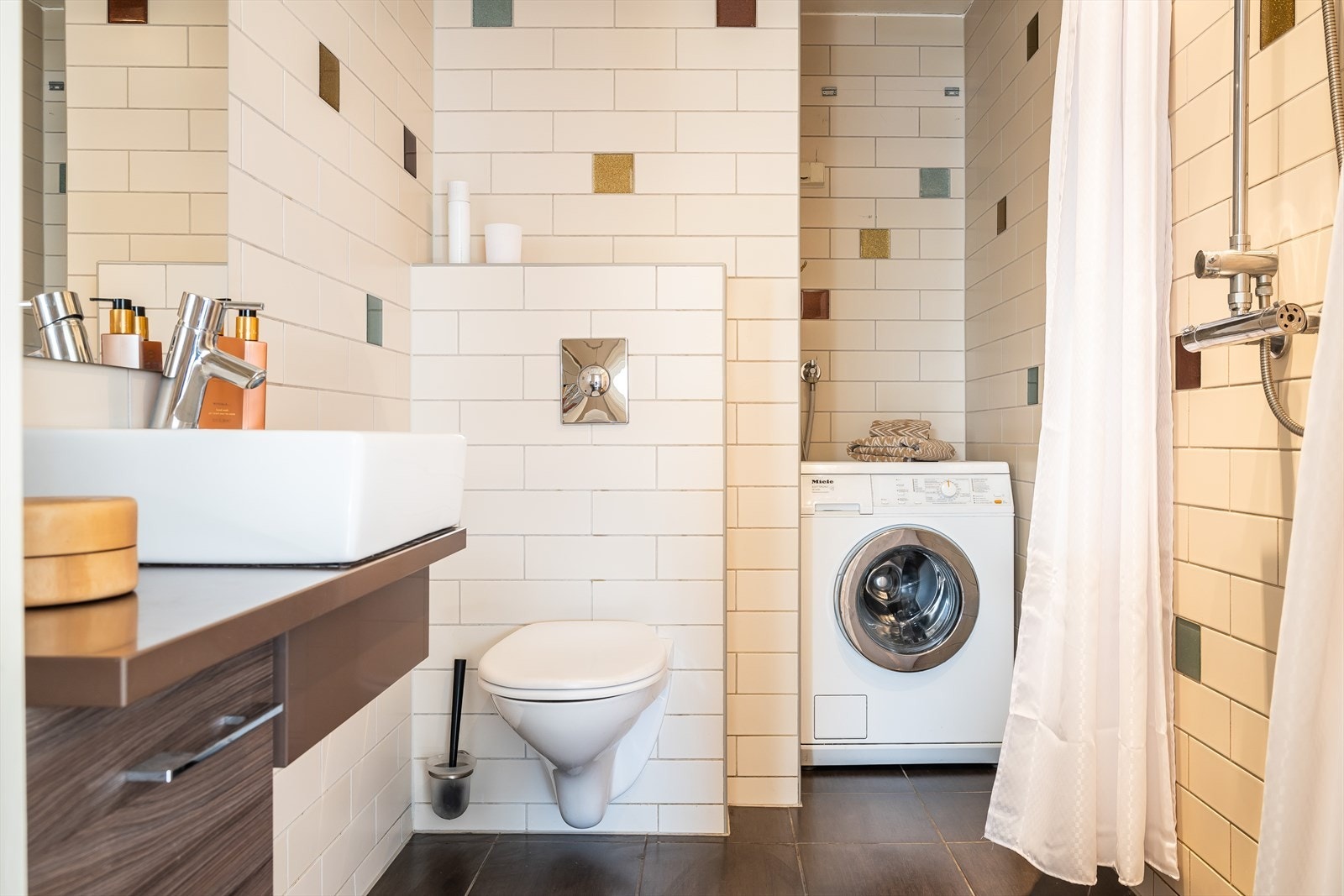 Flislagt bad i 6. etasje med varmekabler, servant og dusj. Det er også opplegg for vaskemaskin Galleribilde