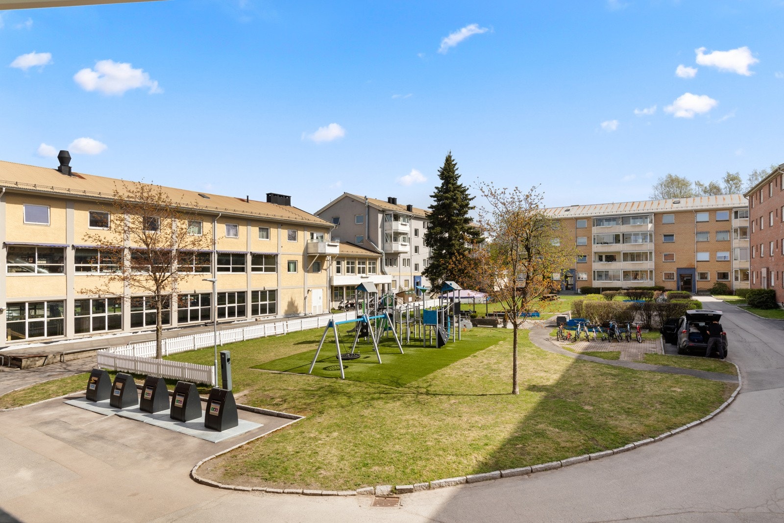 Fellestomten er pent opparbeidet med gressplen, prydbusker, trær og asfalterte internveier, og flere lekeplasser. Galleribilde