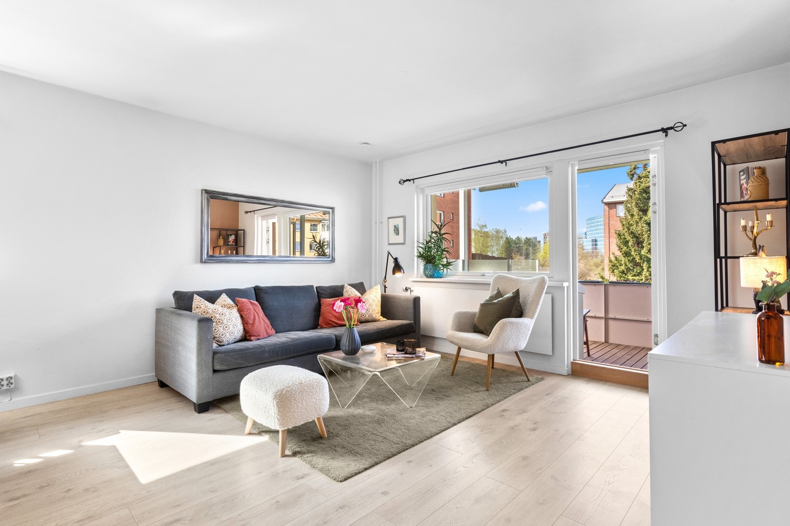 Stuen får godt med naturlig lysinnslipp fra store vindusflater. Vinduer og balkongdører i borettslaget ble skiftet i 2017. Galleribilde