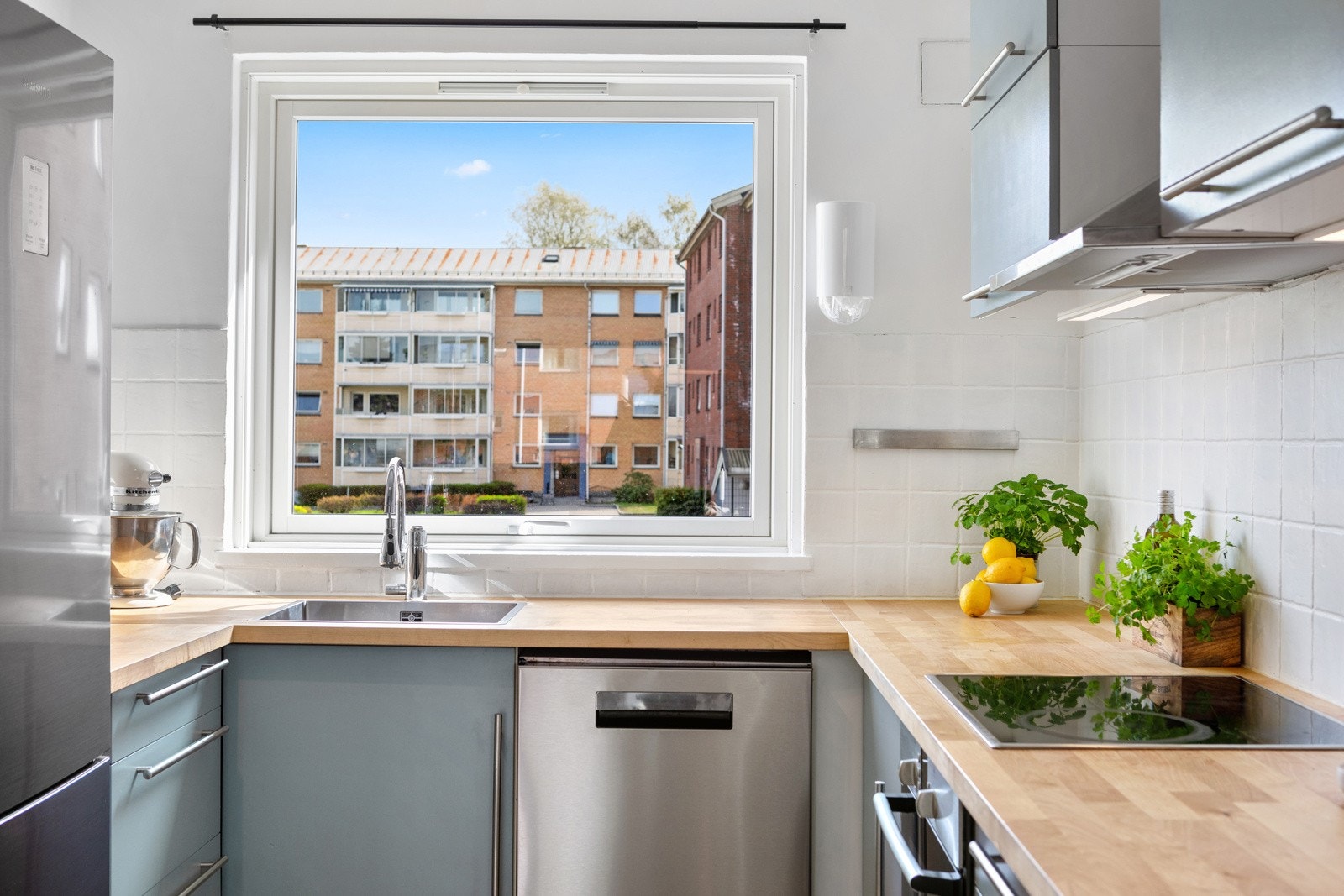 Her er det laminatbenkeplate med nedfelt kum i stål, veggene over benken er kledd med hvite fliser, og under overskapene er det montert god arbeidsbelysning. Galleribilde