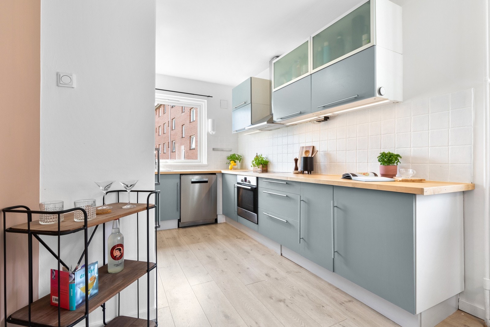 Kjøkkenet har et stilrent og pent design med langstrakte benkeflater og godt med skapplass. Innredningen har grå, glatte fronter som ble malt i 2024. Galleribilde