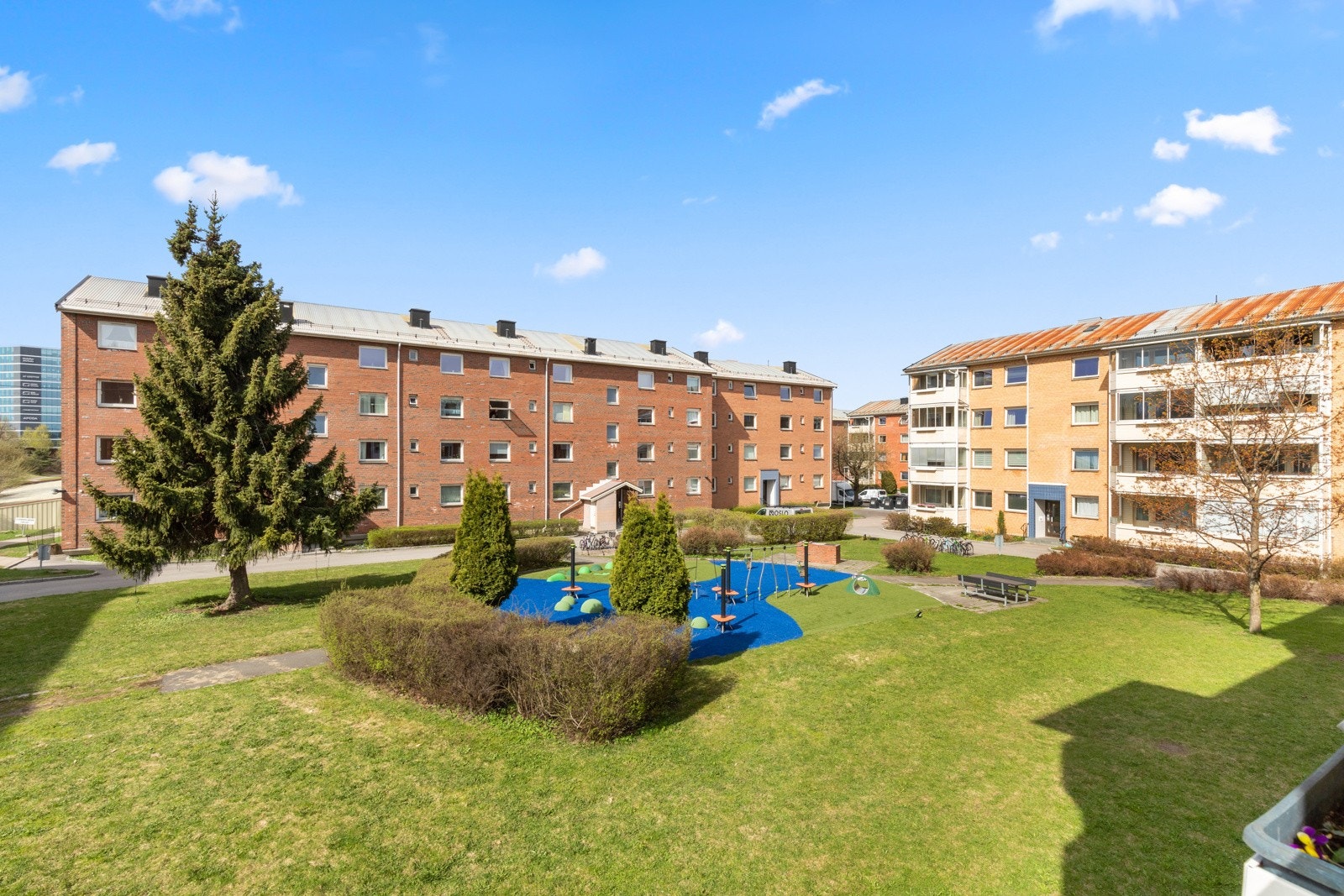 Fra balkongen er det fint utsyn over borettslagets velstelte fellesområder, og på tunet er det lekeplass for de små. Galleribilde