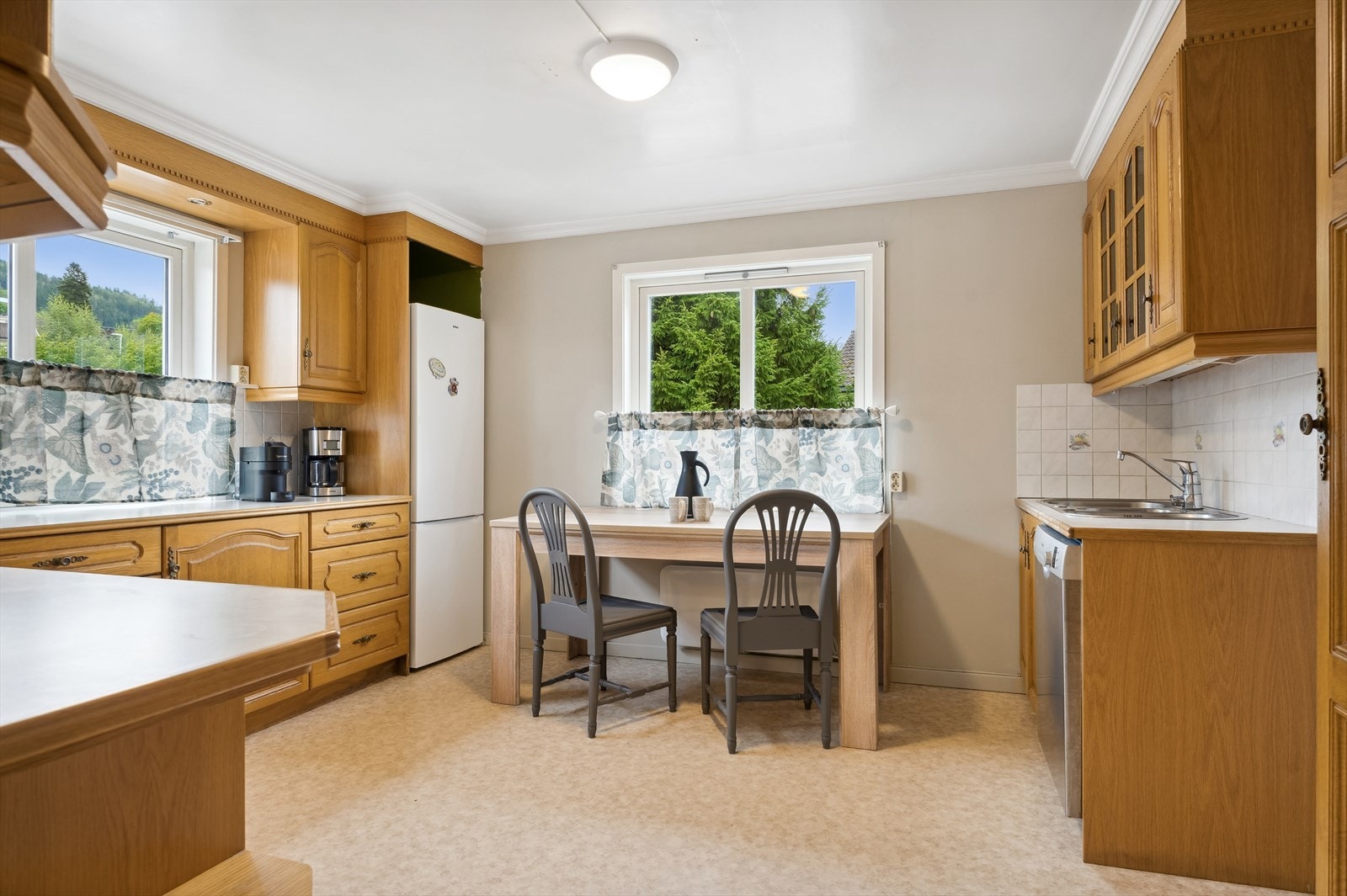 Innholdsrikt kjøkken med rikelig av oppbevaringsmuligheter i skuffer og skap. Galleribilde