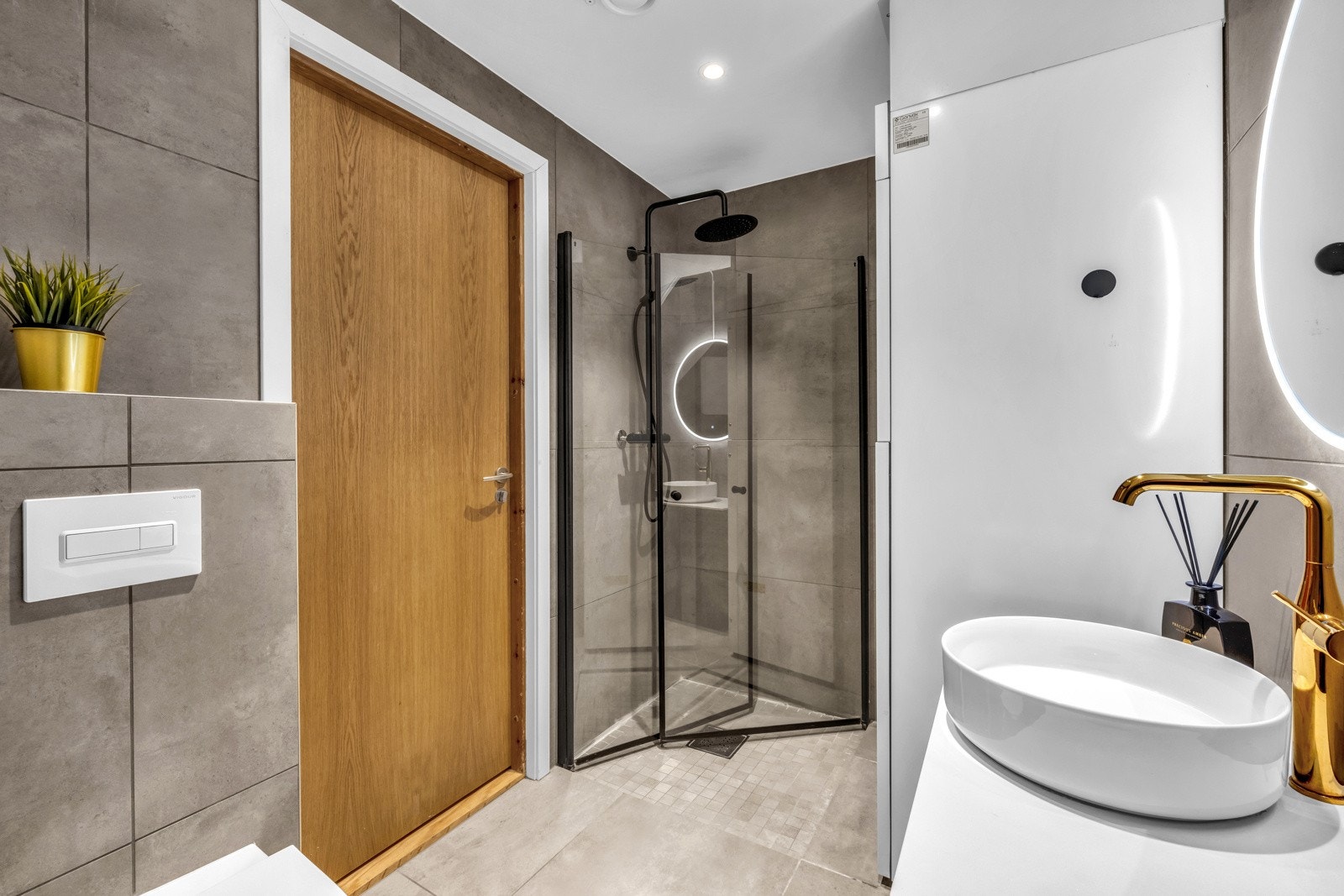 Badet har Vegghengt servantskap med glatte fronter, ovenpåliggende servant med ett-greps armatur og vegghengt speil med integrert lys. Galleribilde