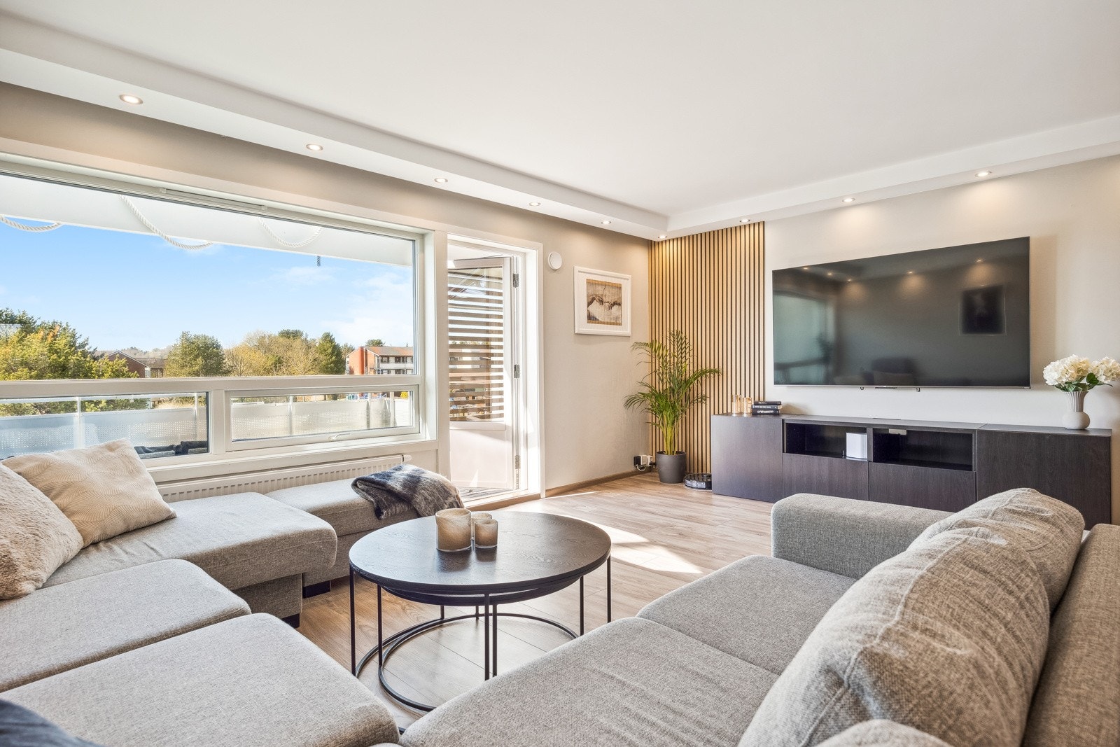 Stuen har store vinduer som gir fint lysinnslipp og utgang til en solrik balkong. Galleribilde