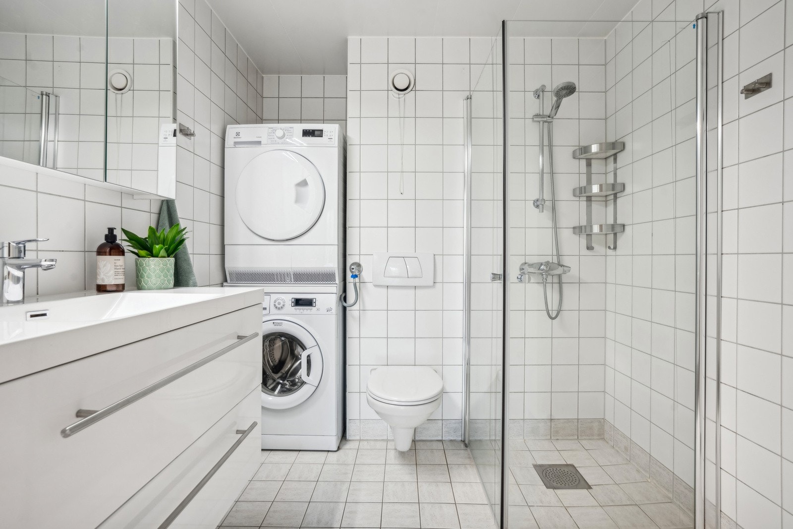 Romslig moderne flislagt bad med varmekabler. Opplegg for vaskemaskin og tørketrommel Galleribilde