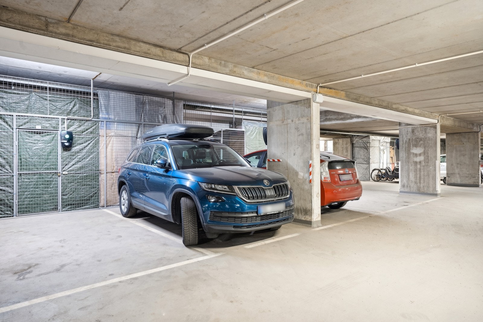 Garasjeplass med elbillading. Bod bak parkeringsplass Galleribilde