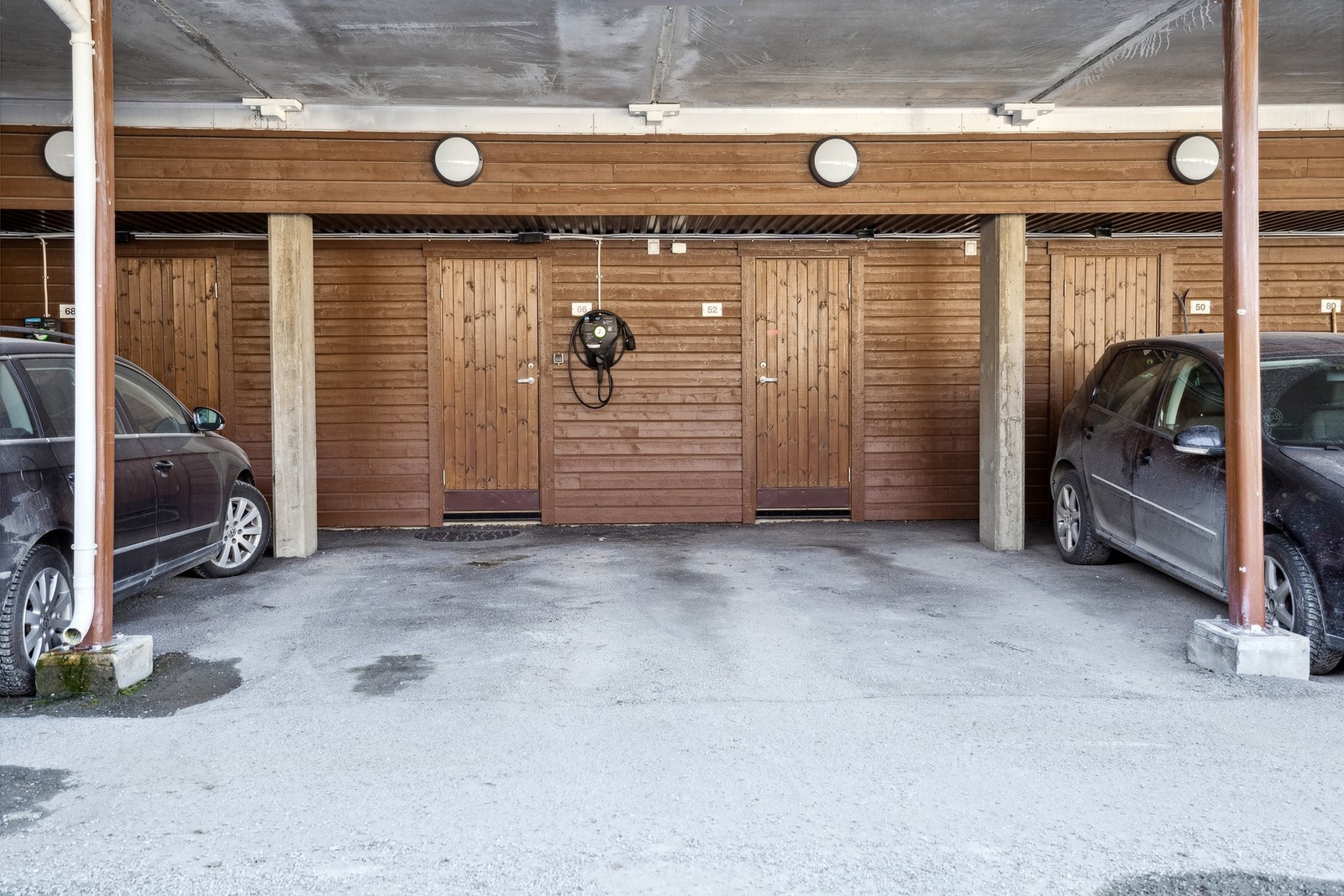 Leilighetens parkeringsplass i carport. Tilrettelagt for å montere el-bil lader. Galleribilde