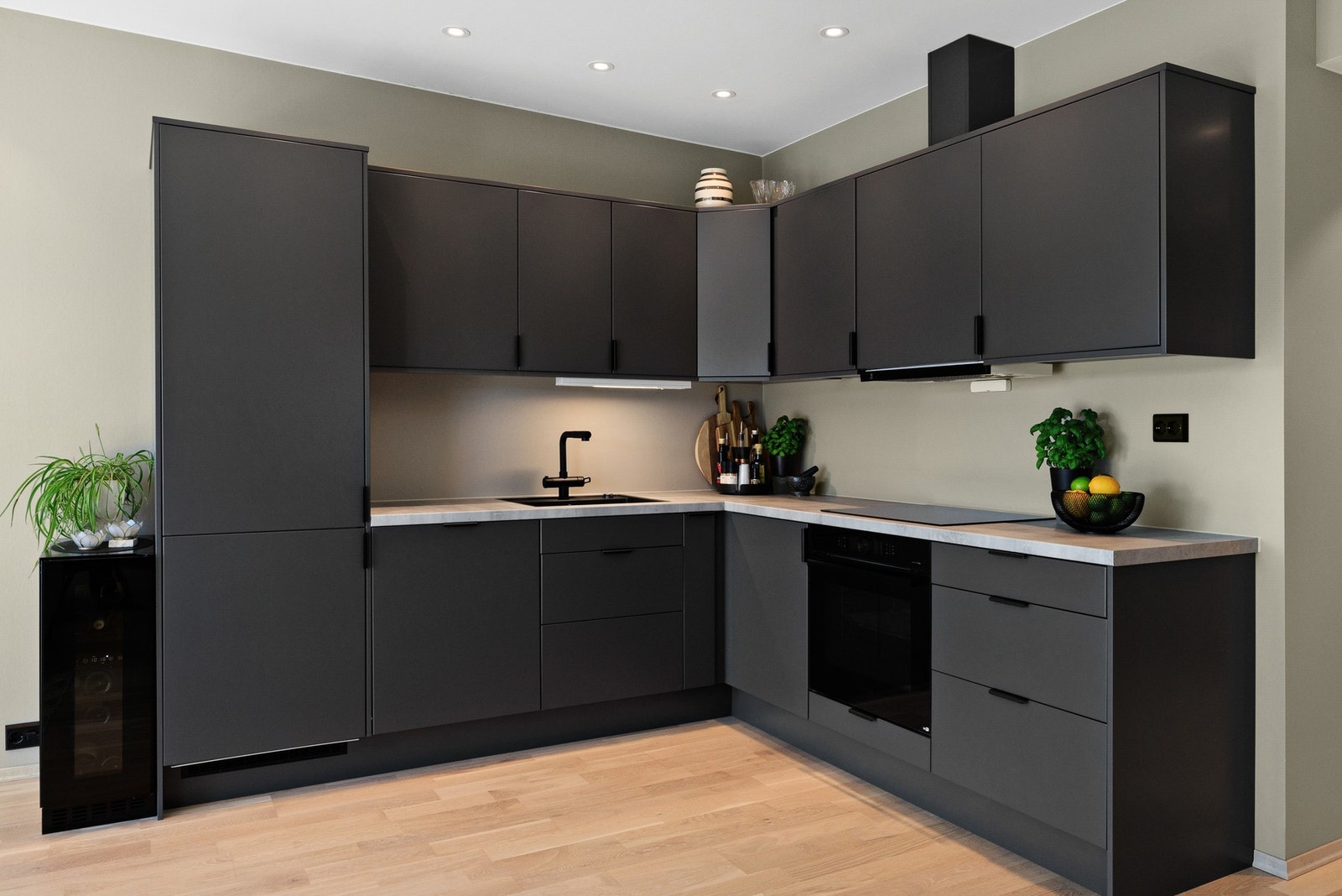 Kjøkkeninnredning med mørke slette fronter og lys laminert benkeplate. Integrerte hvitevarer fra Bosch Galleribilde